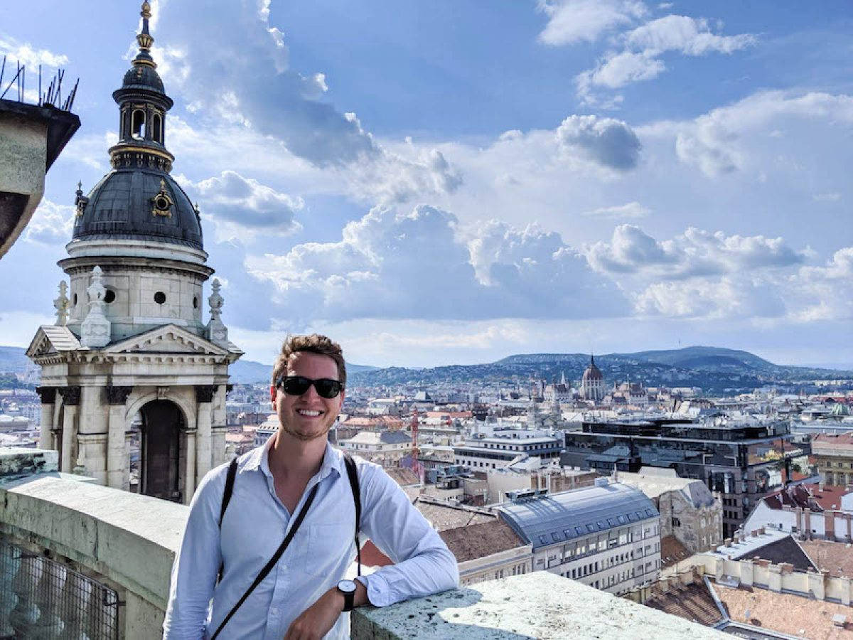 A Man Standing On A Rooftop Overlooking A City