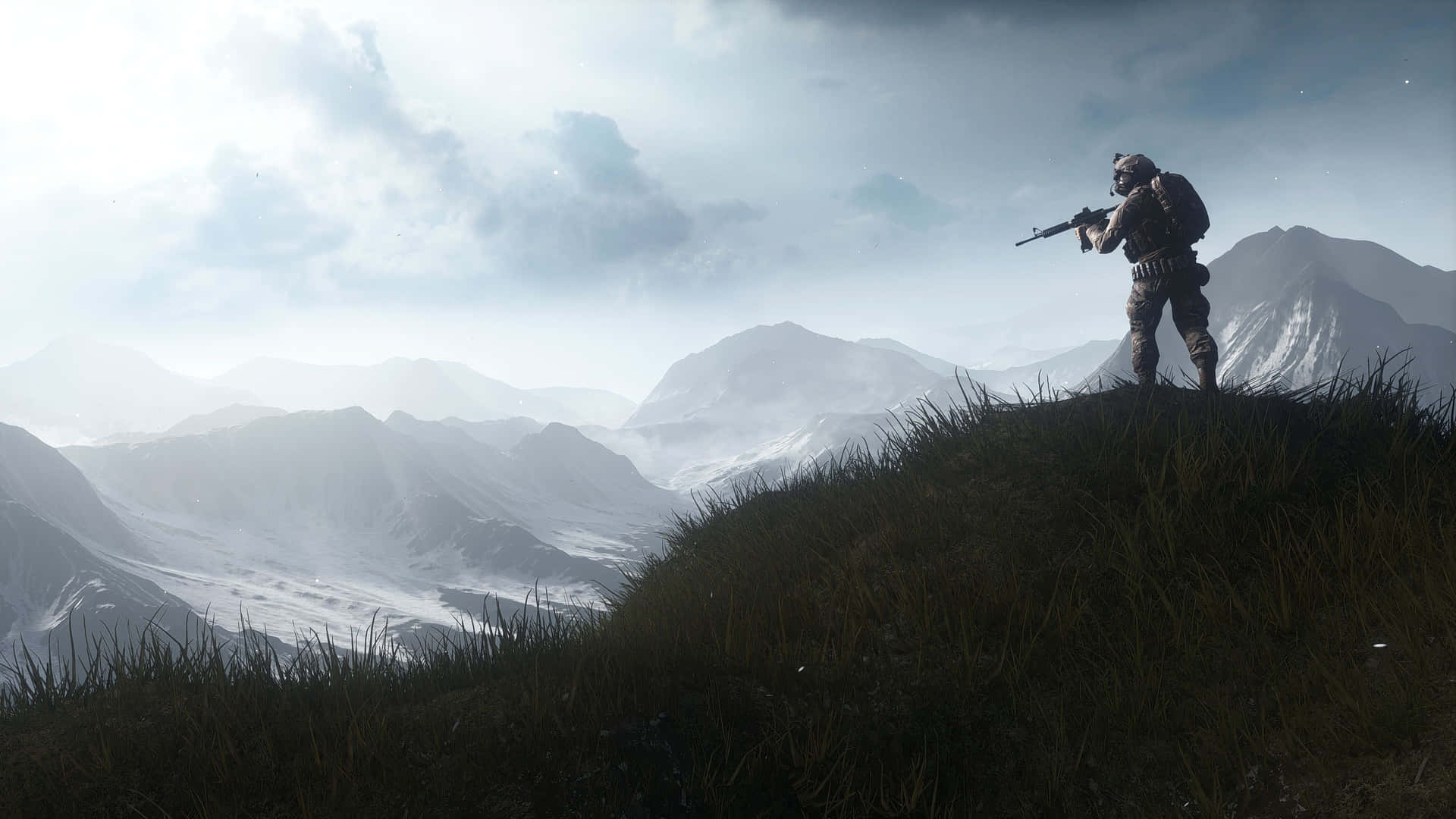 A Man Standing On Top Of A Mountain With A Rifle Background