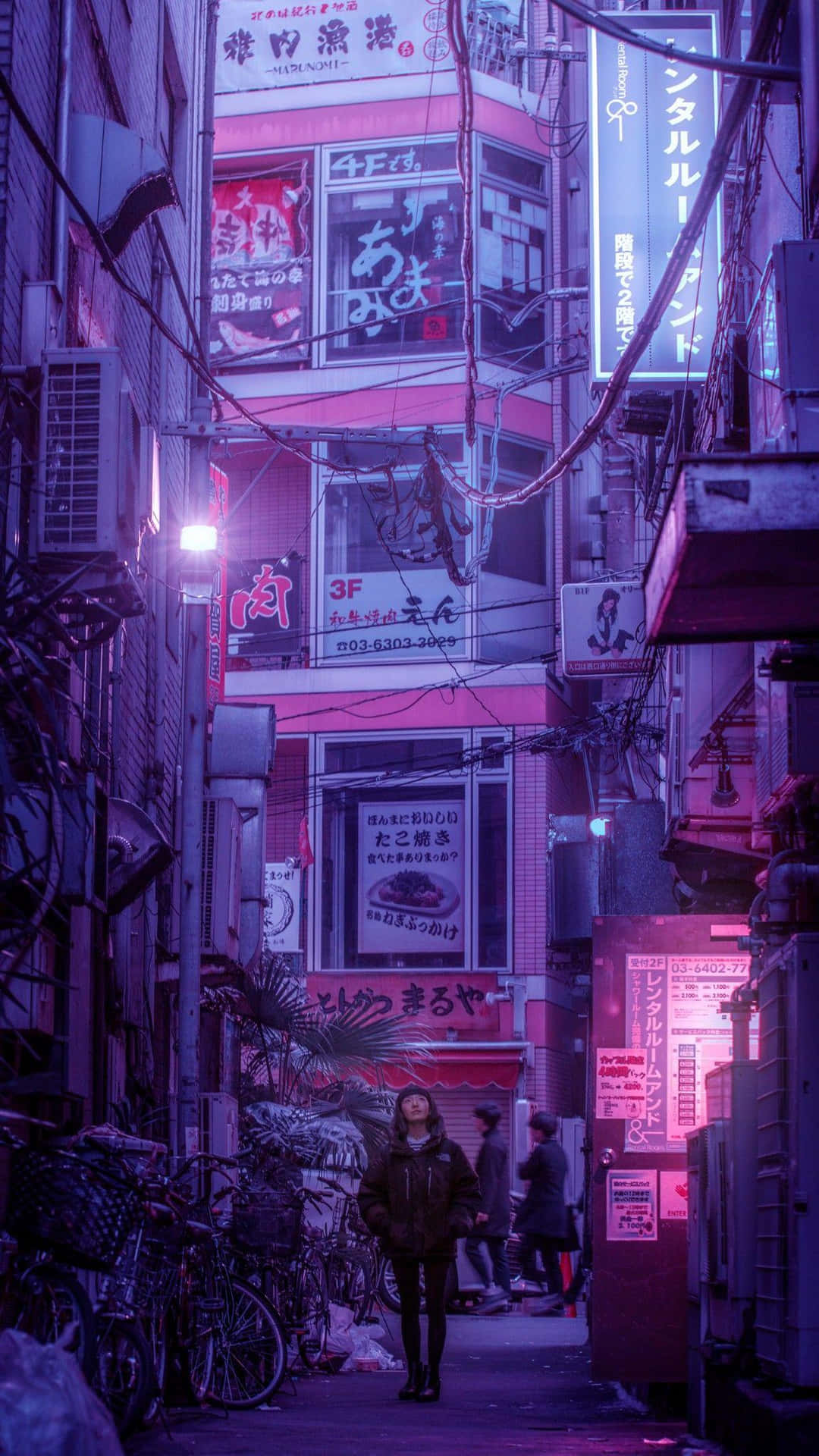 A Man Walking Down A Street At Night Background