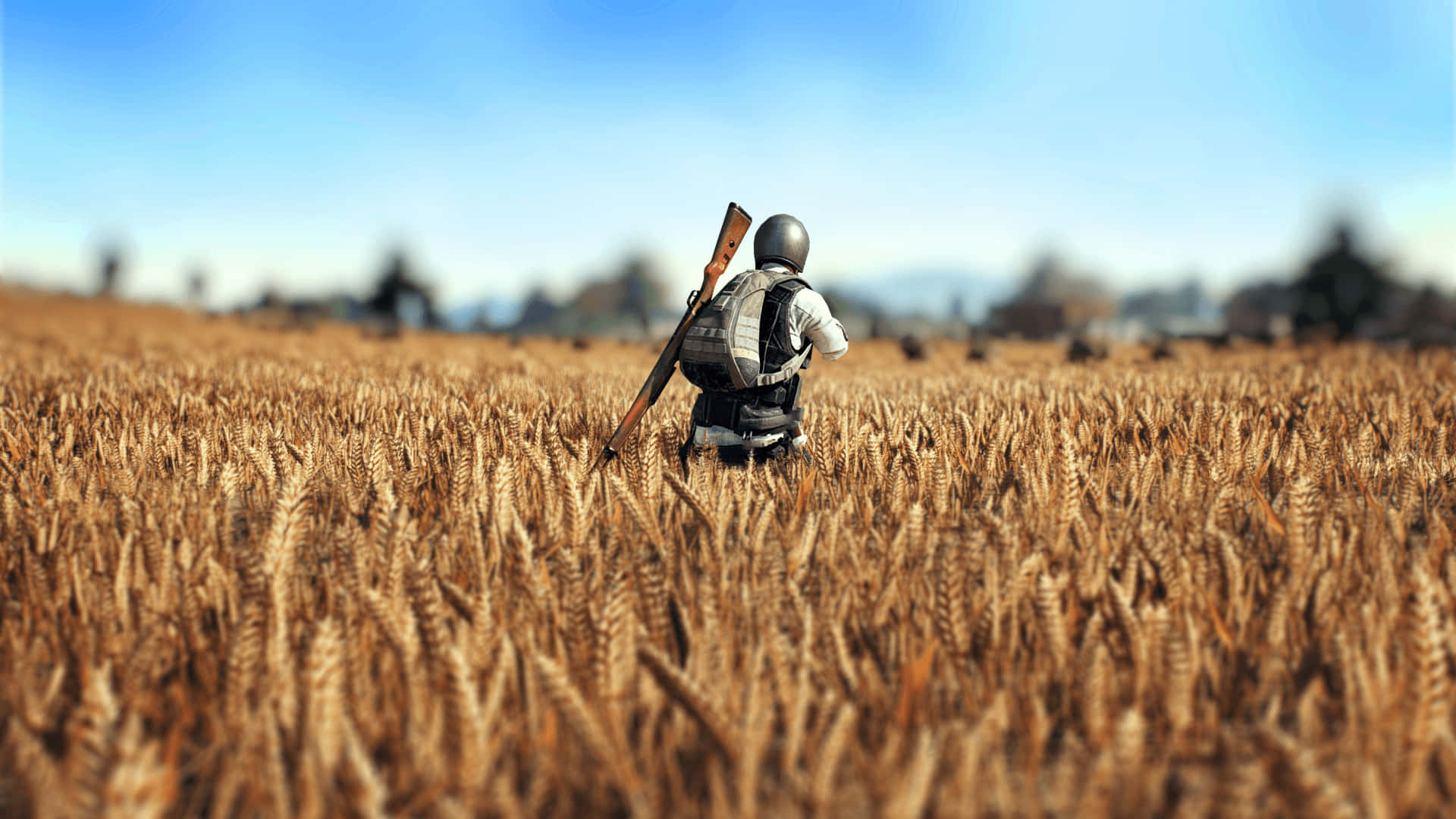 A Man Walking Through A Field With A Rifle Background