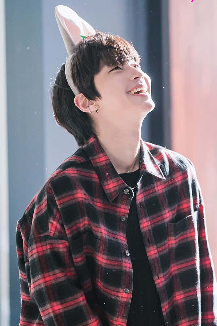 A Man Wearing A Bunny Hat And A Plaid Shirt Background