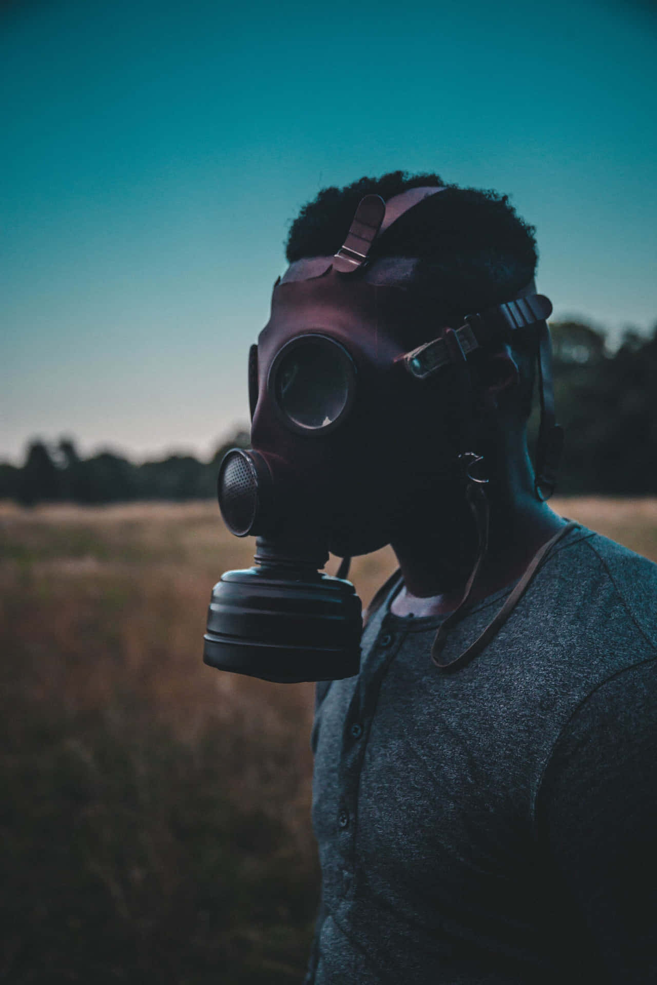 A Man Wearing A Gas Mask In A Field Background