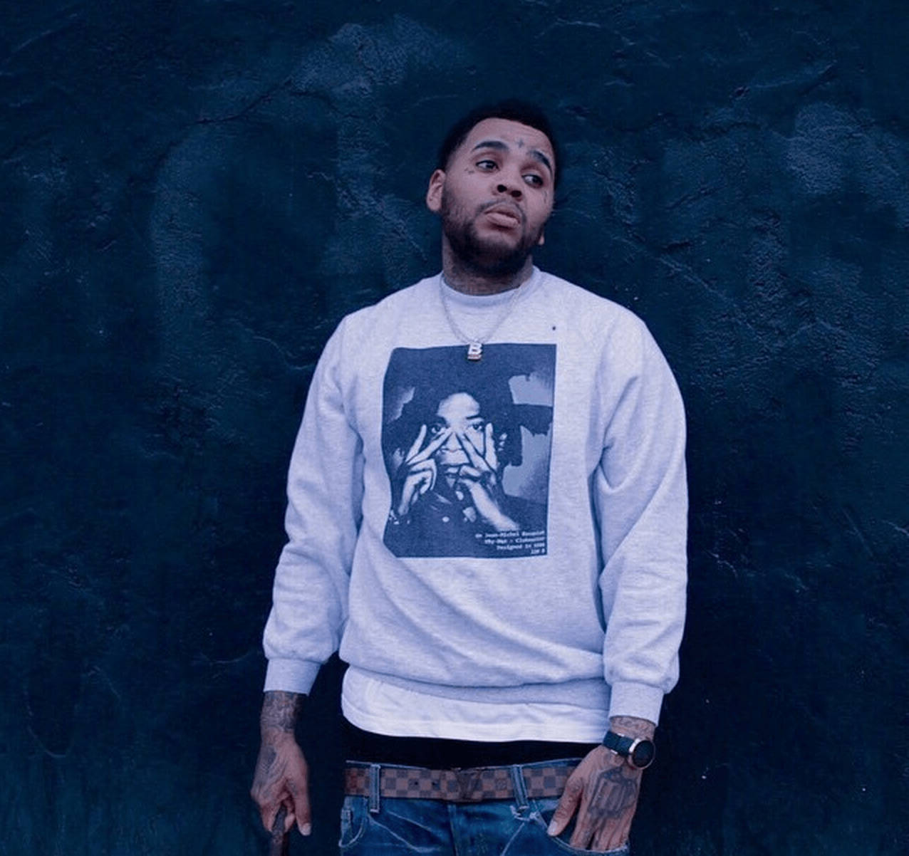 A Man Wearing A Grey Sweatshirt With A Picture Of A Man Background