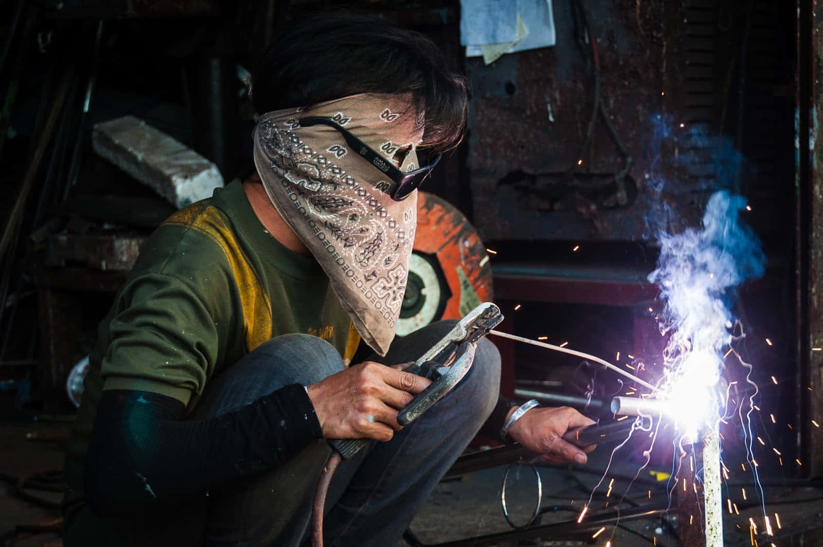 A Man Welding In A Workshop With Sparks