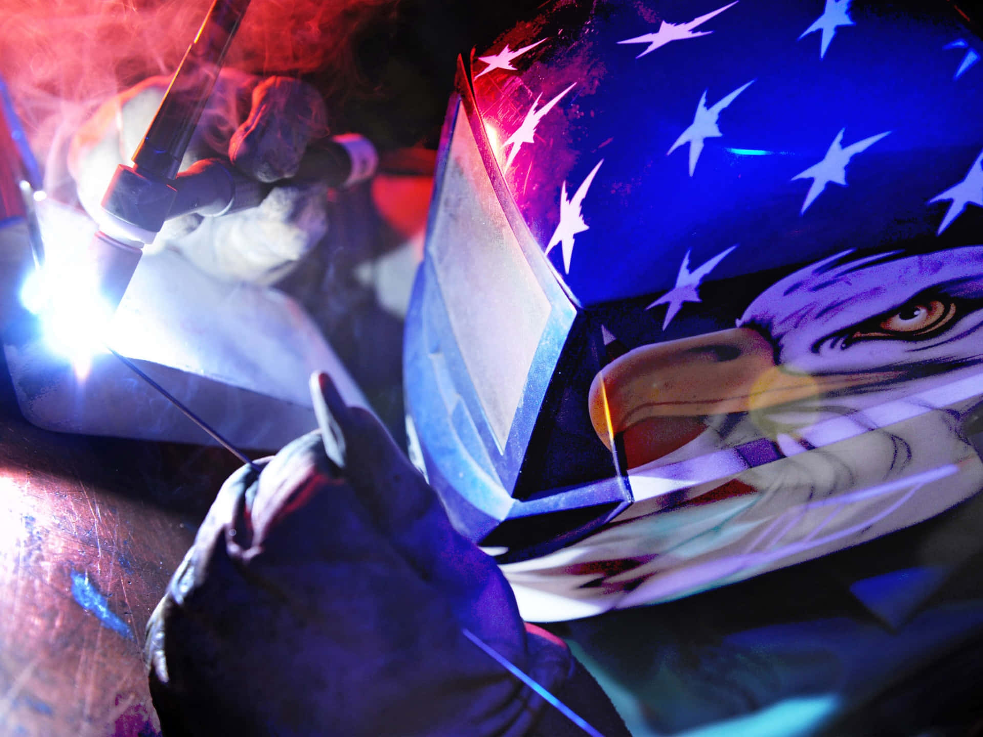 A Man Welding With An American Flag On His Helmet Background