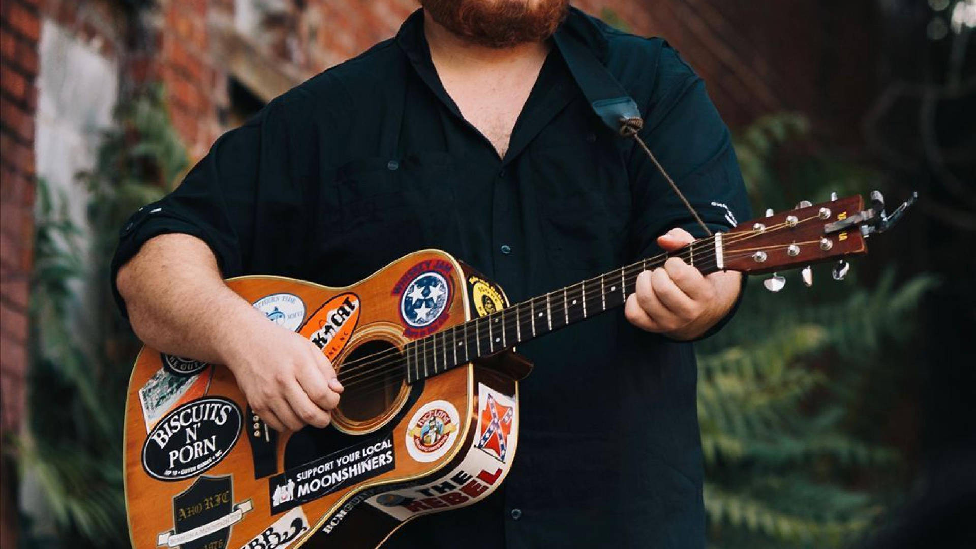 A Man With A Beard And A Guitar Background