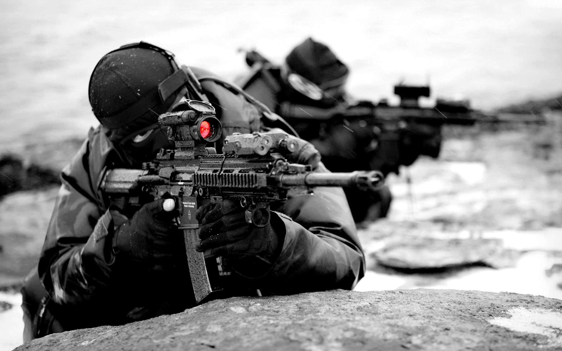 A Man With A Gun Is Laying On The Ground Background