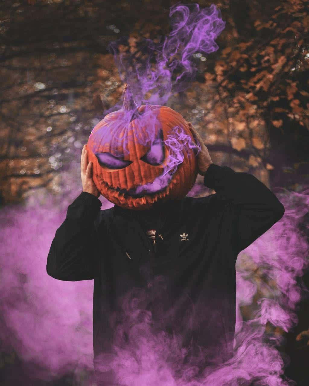 A Man With A Purple Pumpkin Mask And Smoke Background