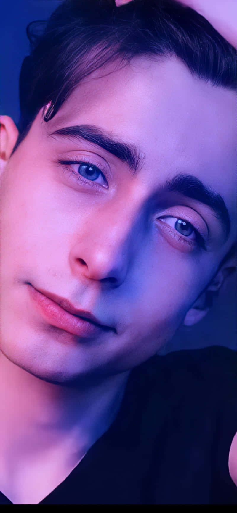 A Man With Blue Eyes Is Posing With His Head Down Background