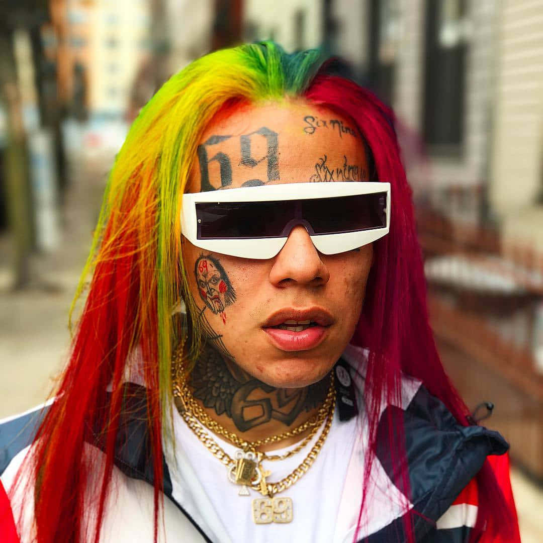 A Man With Colorful Hair And Sunglasses Background