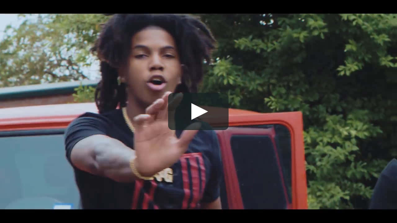 A Man With Dreadlocks Is Standing Next To A Truck Background