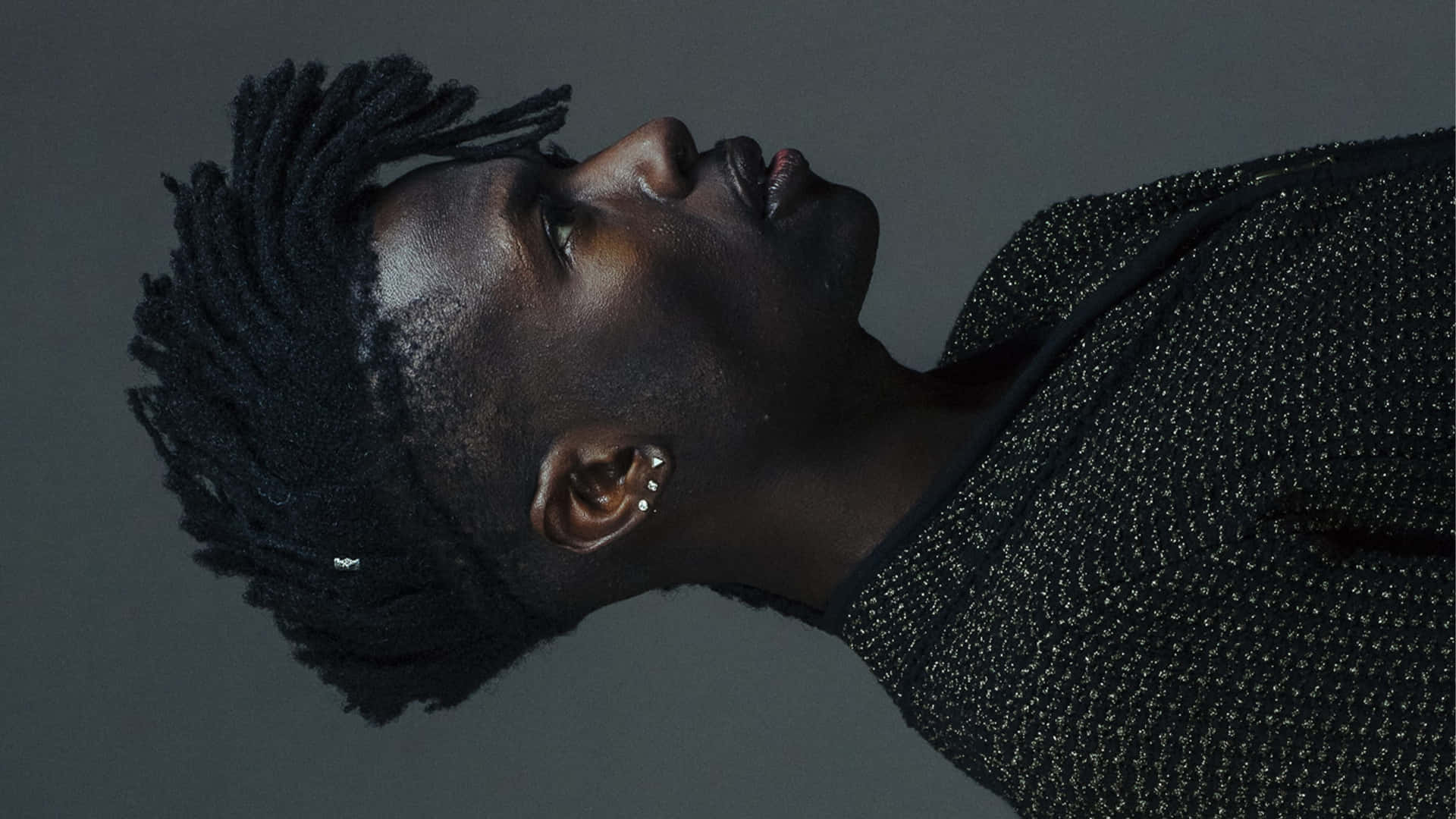 A Man With Dreadlocks Looking Up At The Sky Background