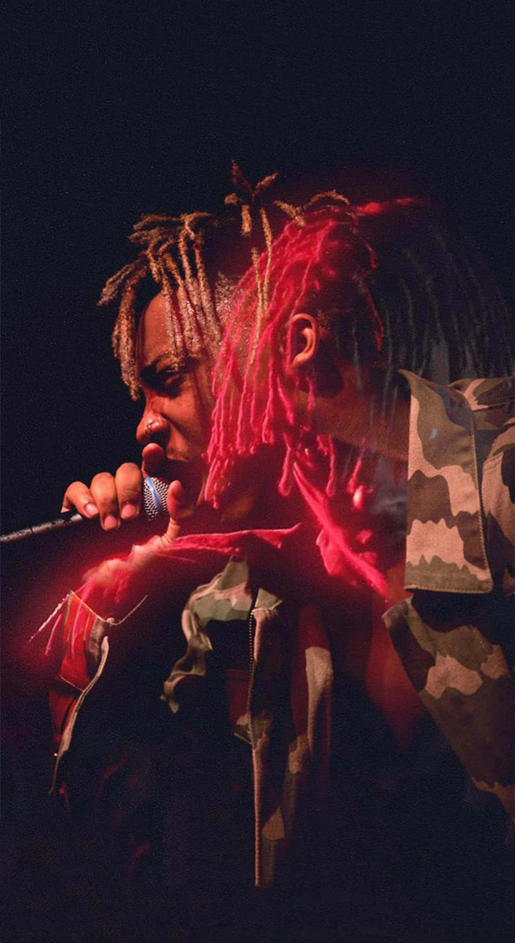 A Man With Dreadlocks Singing Into A Microphone Background