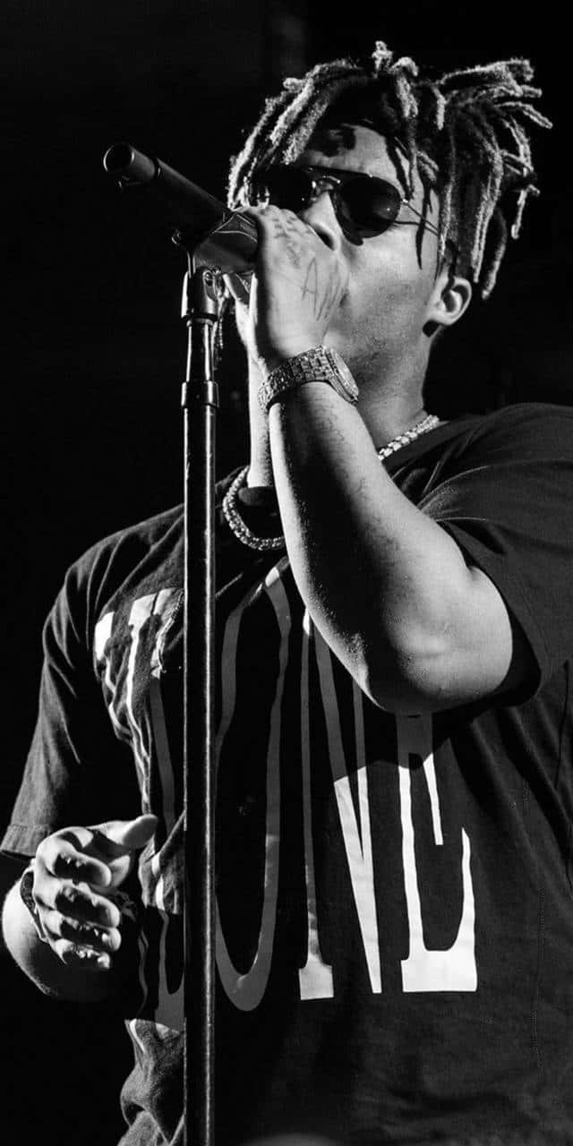 A Man With Dreadlocks Singing Into A Microphone Background
