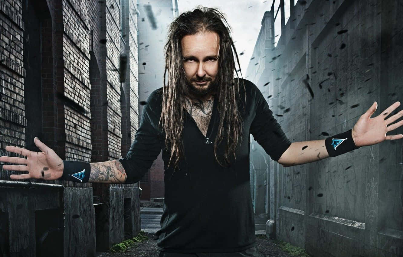 A Man With Dreadlocks Standing In An Alleyway Background