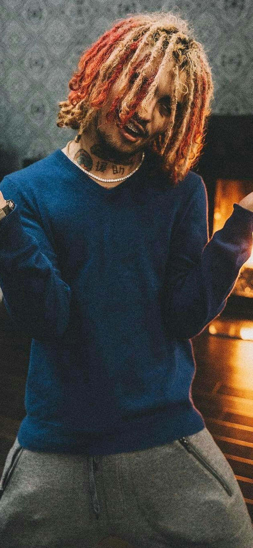 A Man With Dreadlocks Standing In Front Of A Fireplace Background