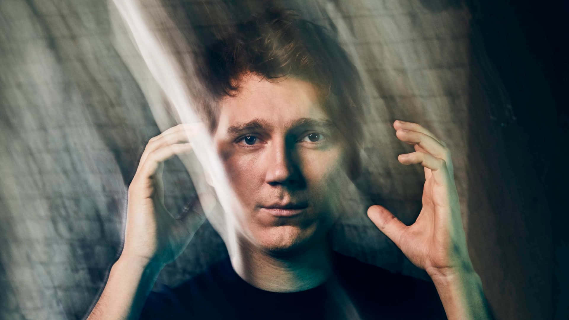 A Man With His Hands Up In Front Of A Mirror Background