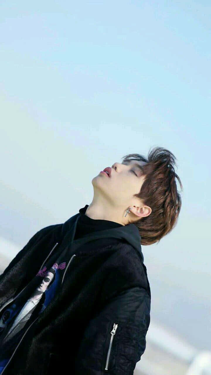 A Man With His Head Up Looking Up At The Sky Background