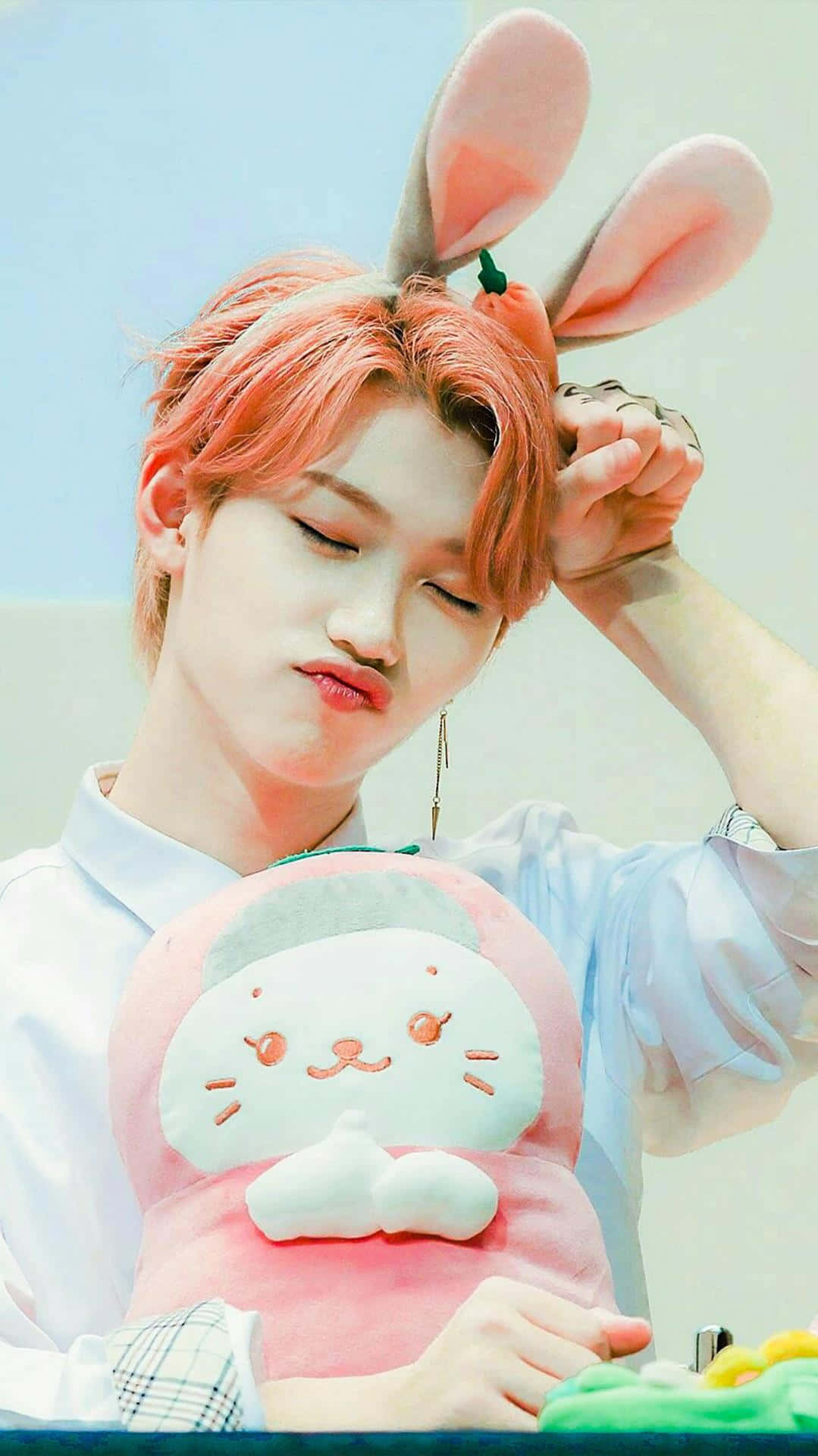 A Man With Pink Hair Holding A Pink Bunny Stuffed Animal Background