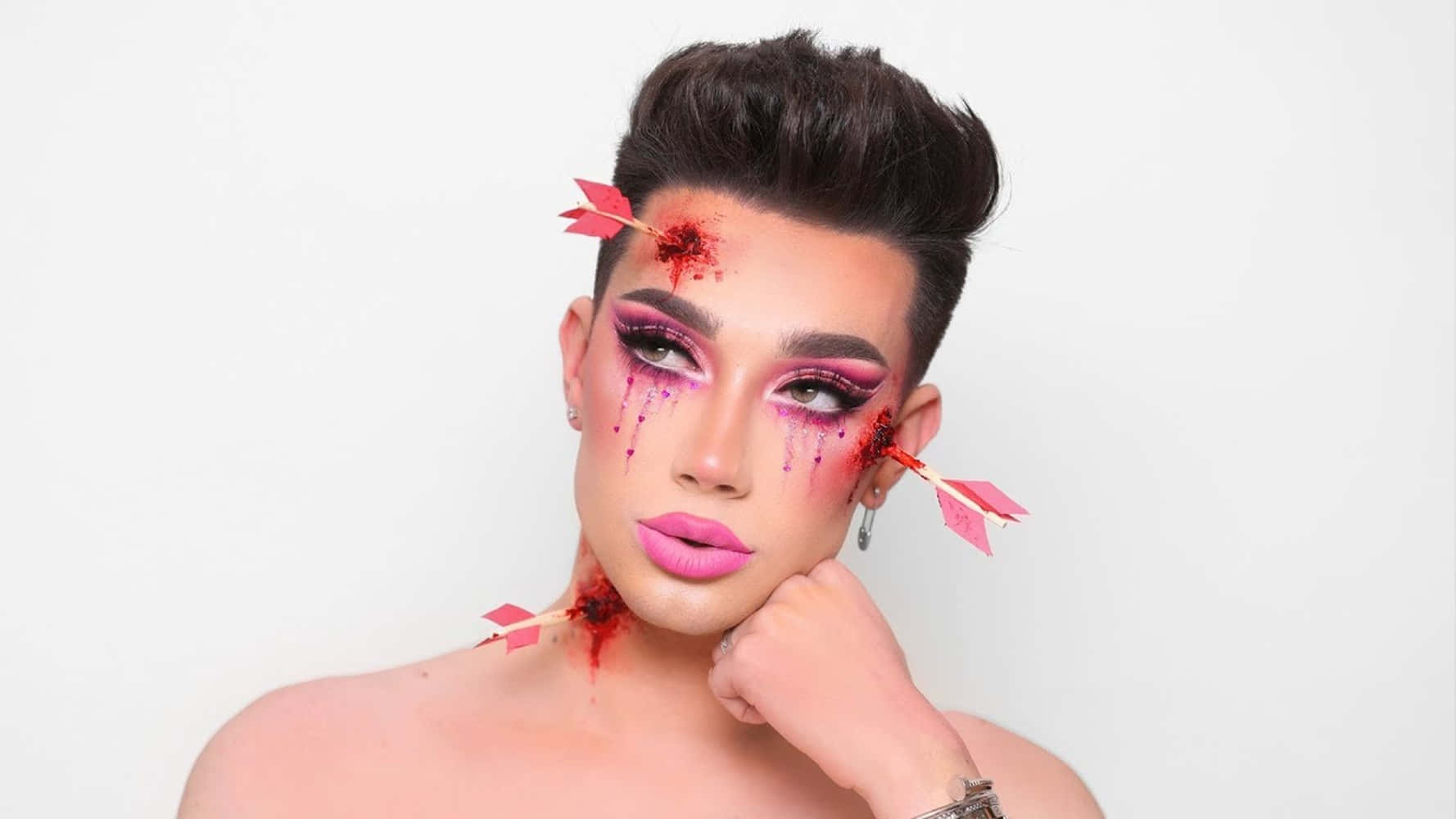 A Man With Pink Makeup And Arrows On His Face