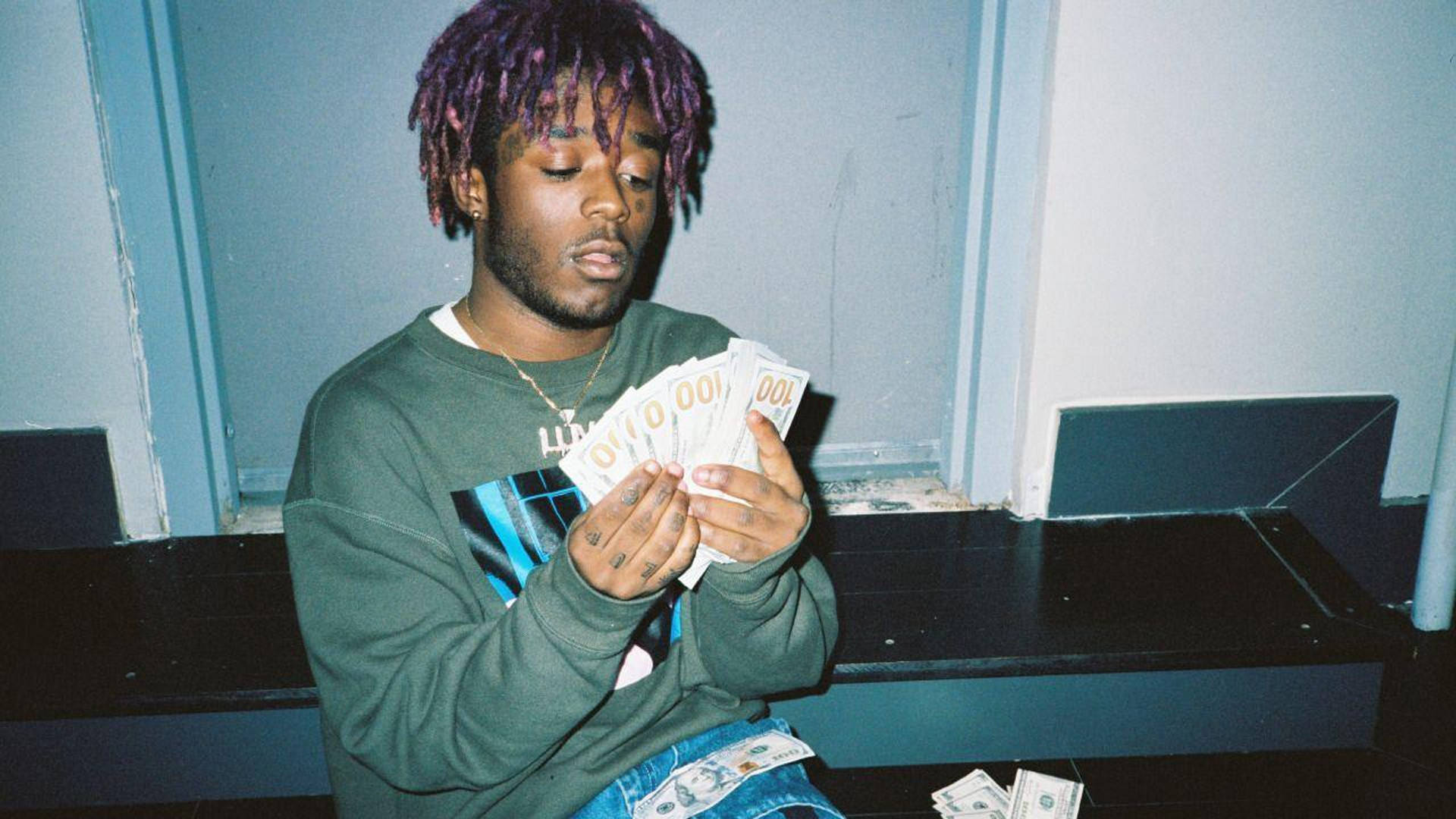 A Man With Purple Hair Holding Money Background