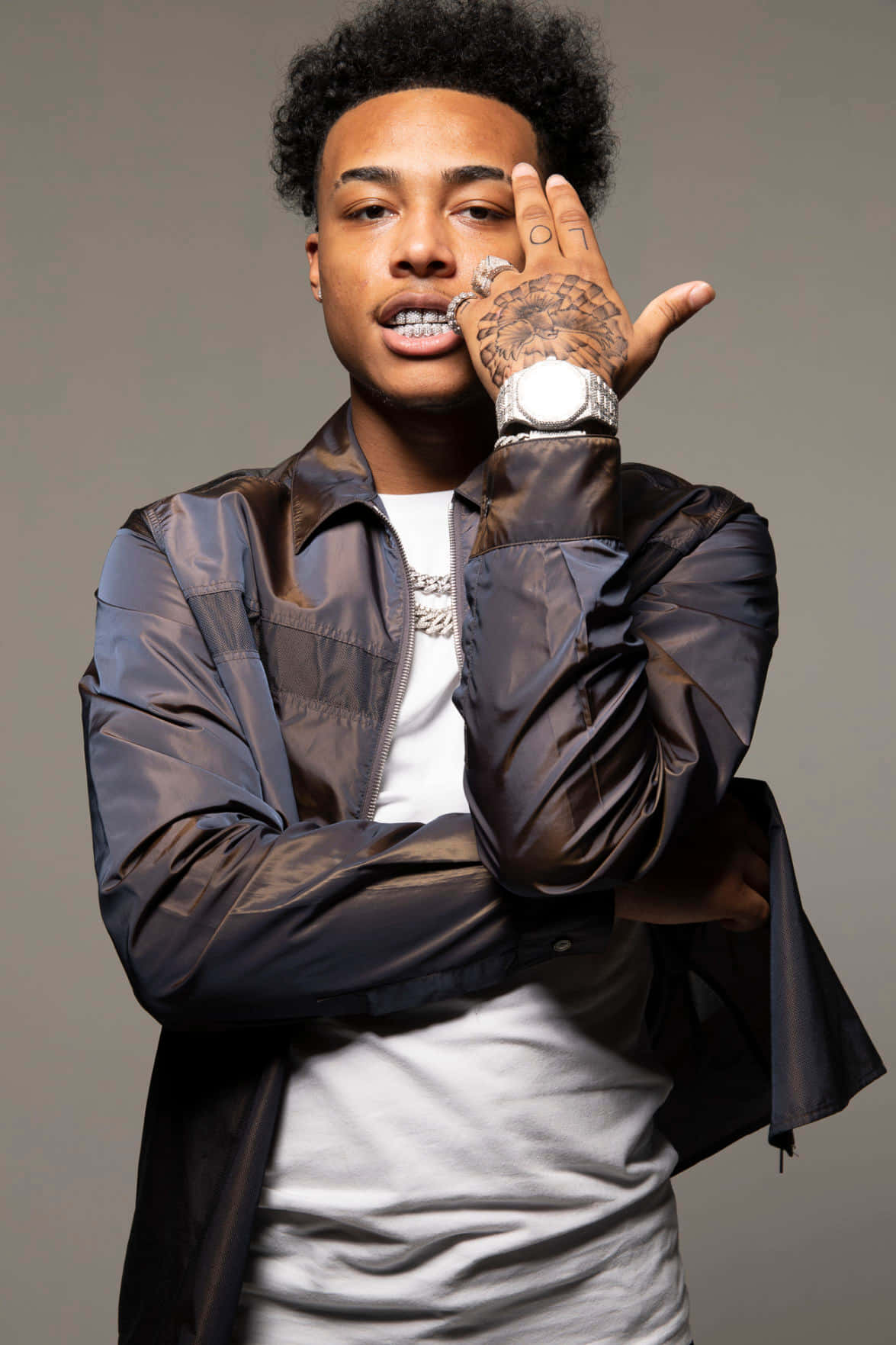 A Man With Tattoos And A Jacket Background