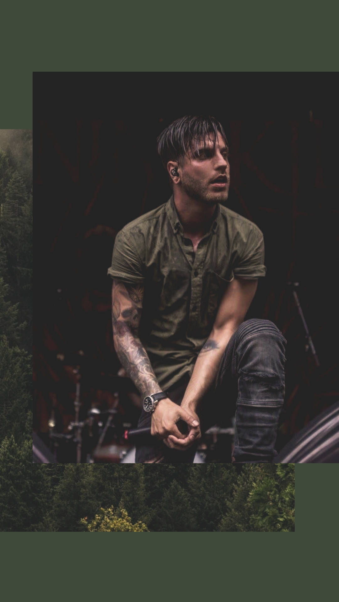 A Man With Tattoos Sitting On A Stage In The Forest