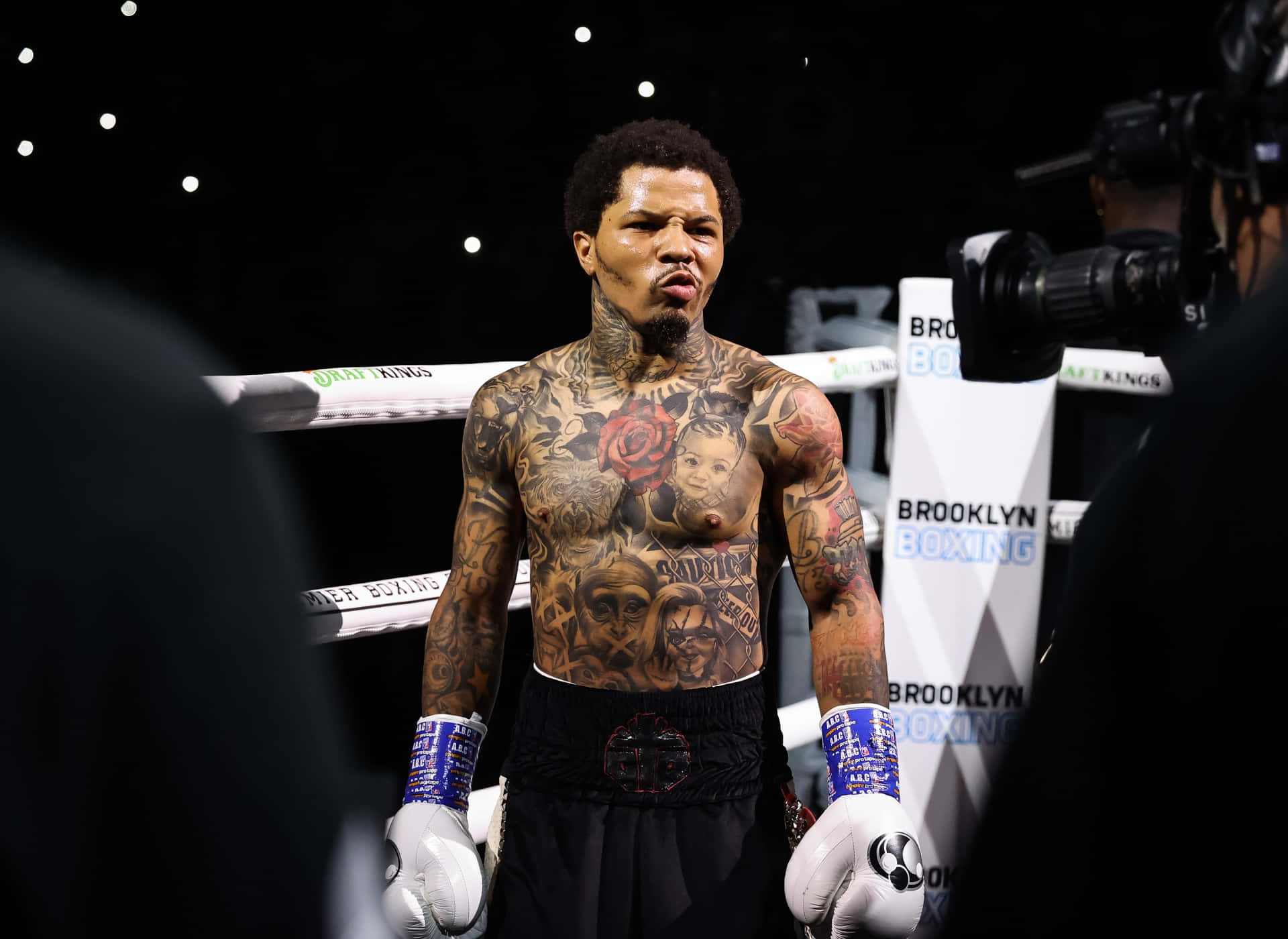 A Man With Tattoos Standing In A Boxing Ring Background