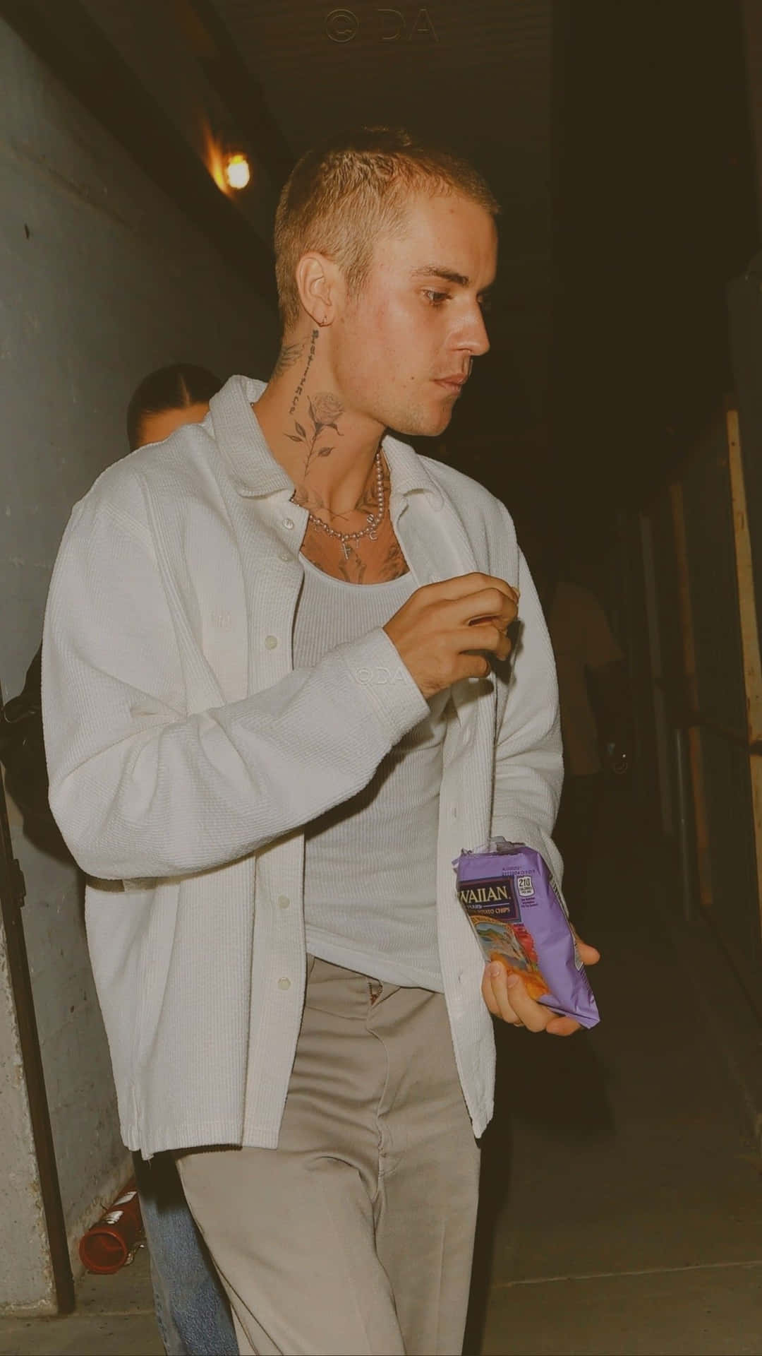 A Man With Tattoos Walking Down The Street Background