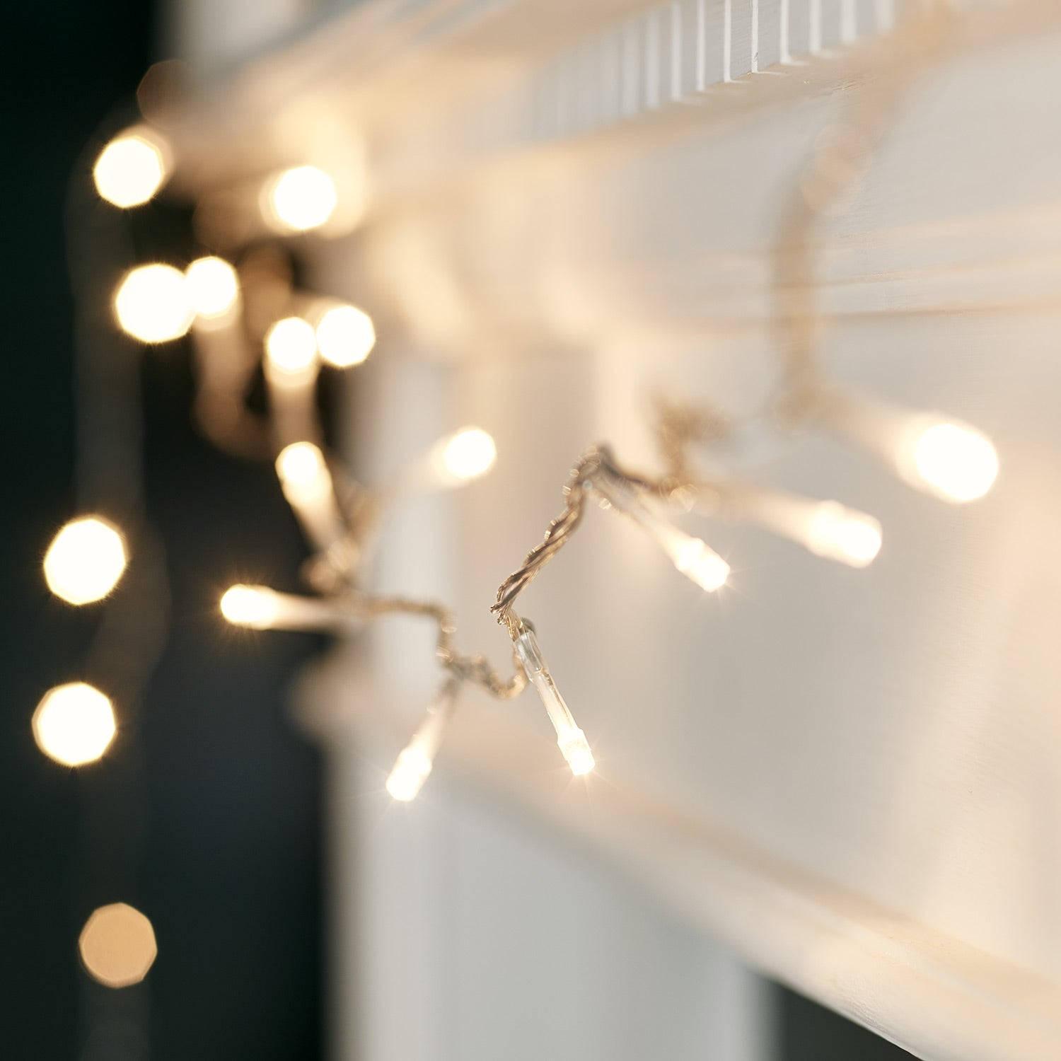 A Mantle With A String Of Lights Hanging From It Background