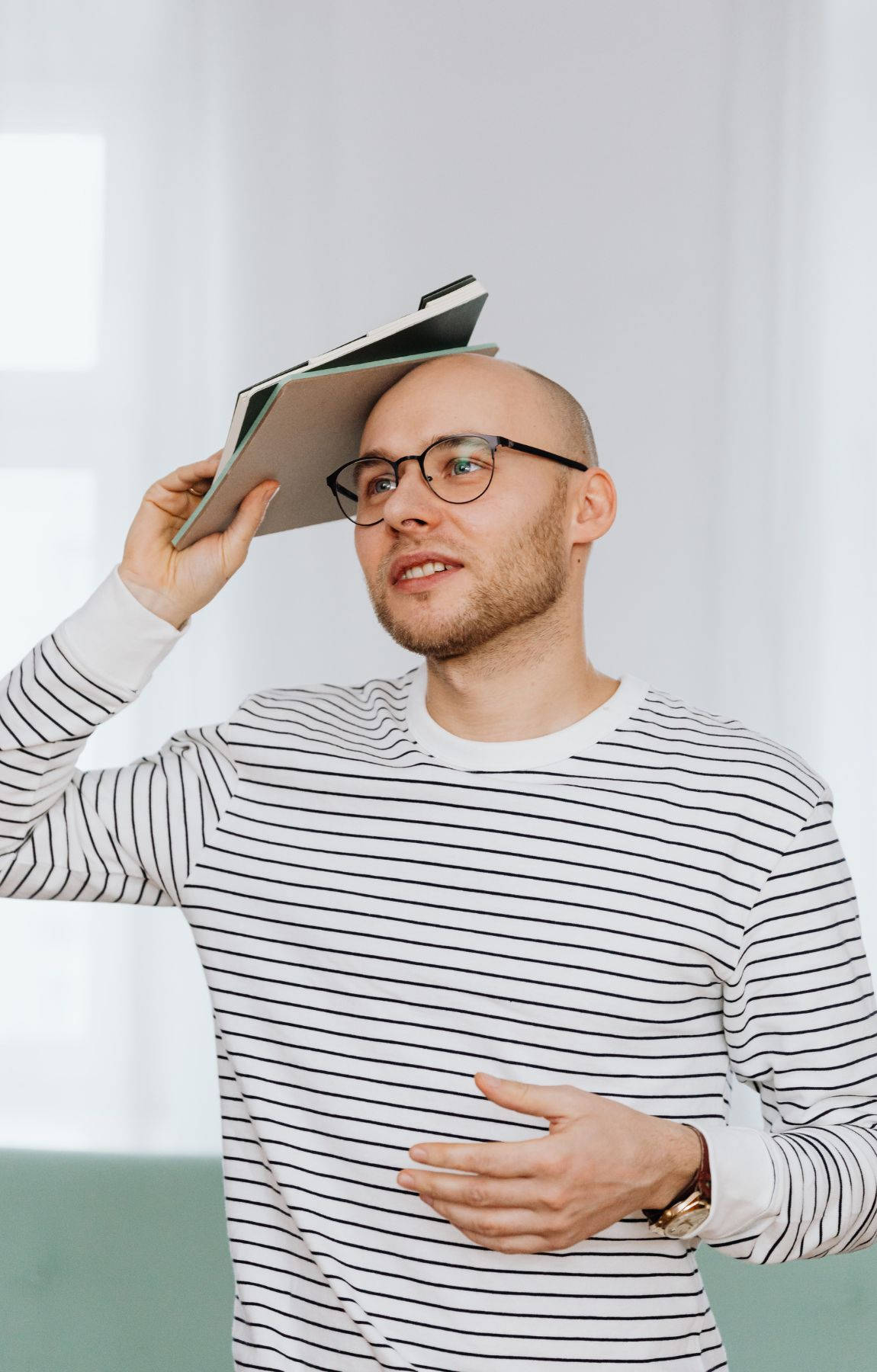 A Mature Bald Man Deeply Engrossed In Reading A Stack Of Books Background