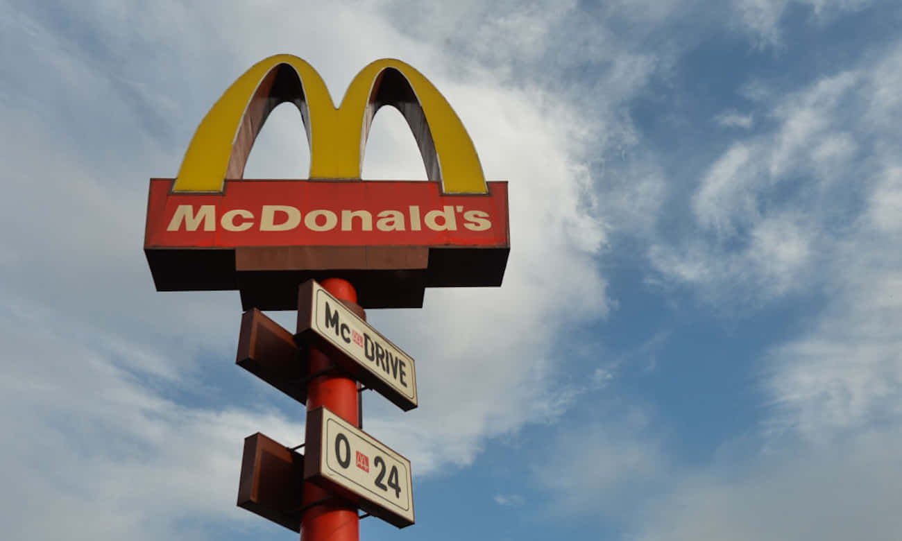 A Mcdonald's Sign Is Shown Against A Blue Sky Background