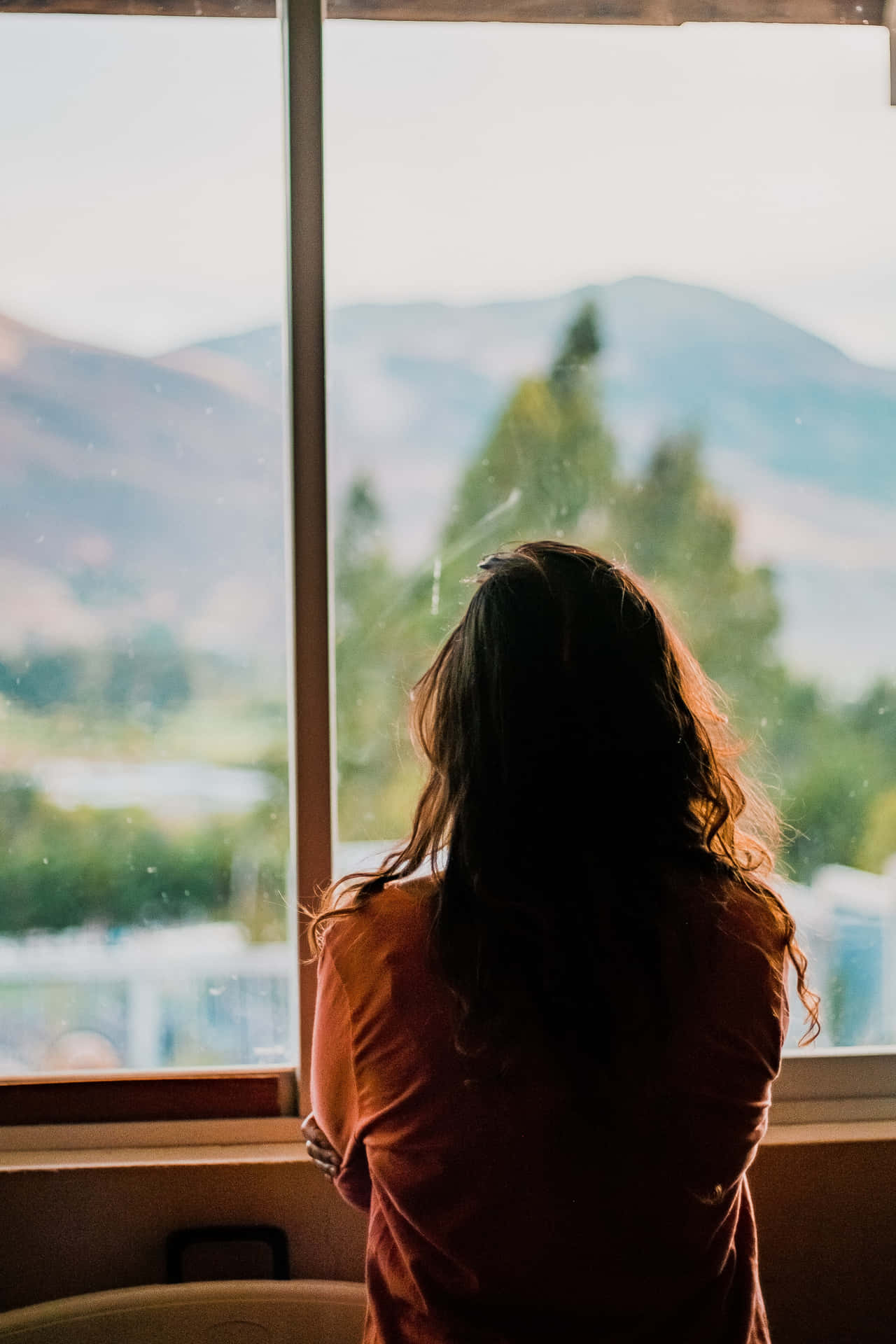 A Melancholic Moment: Young Woman Feeling Sad By The Window Background