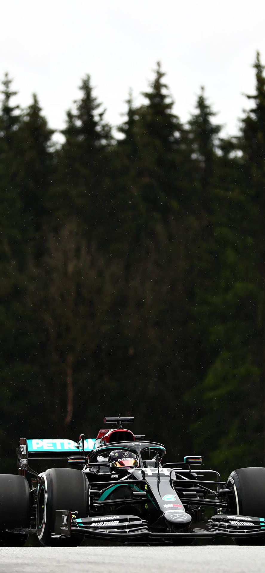 A Mercedes F1 Car Driving On A Track Background