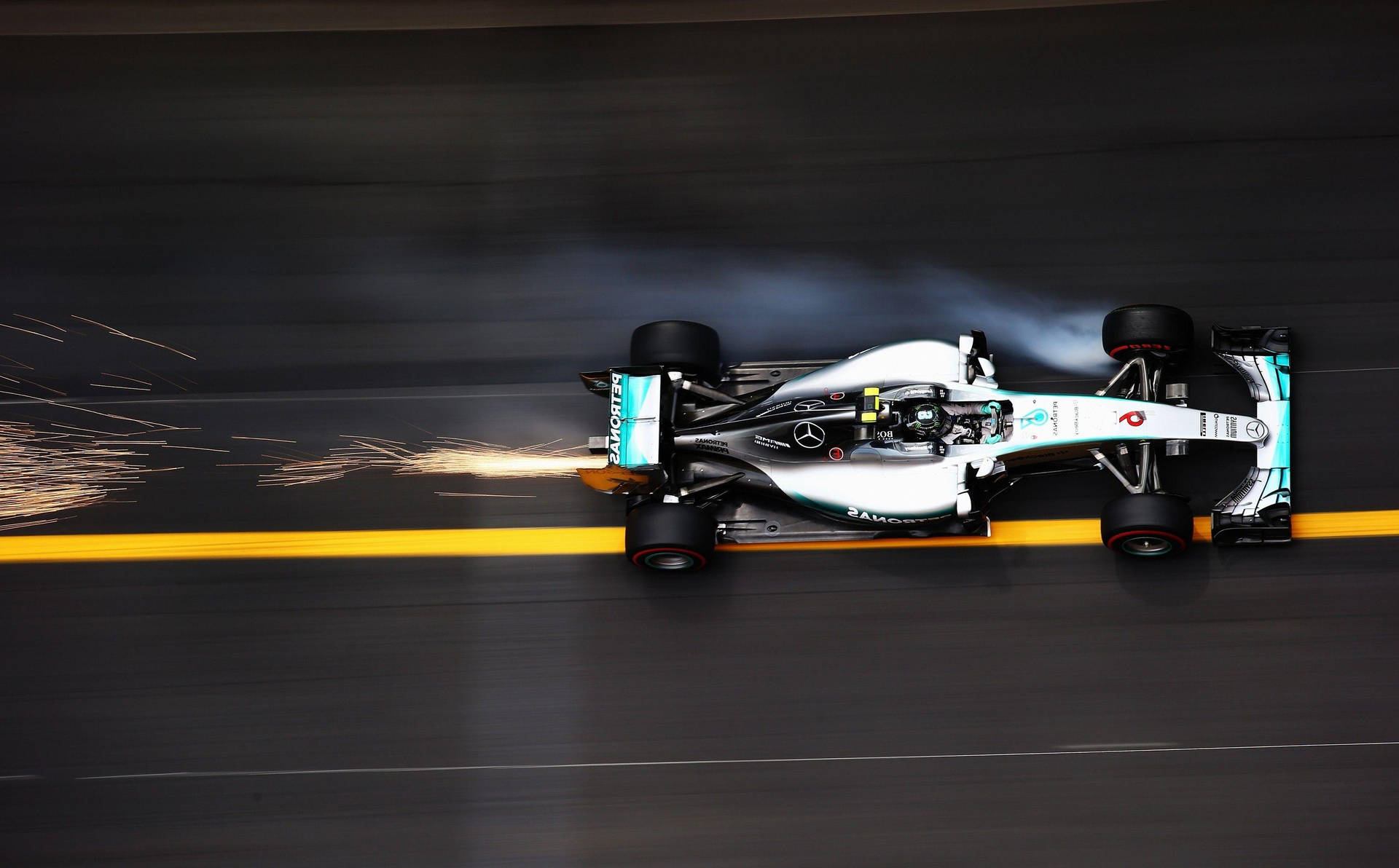 A Mercedes Racing Car Is Driving Down The Track Background