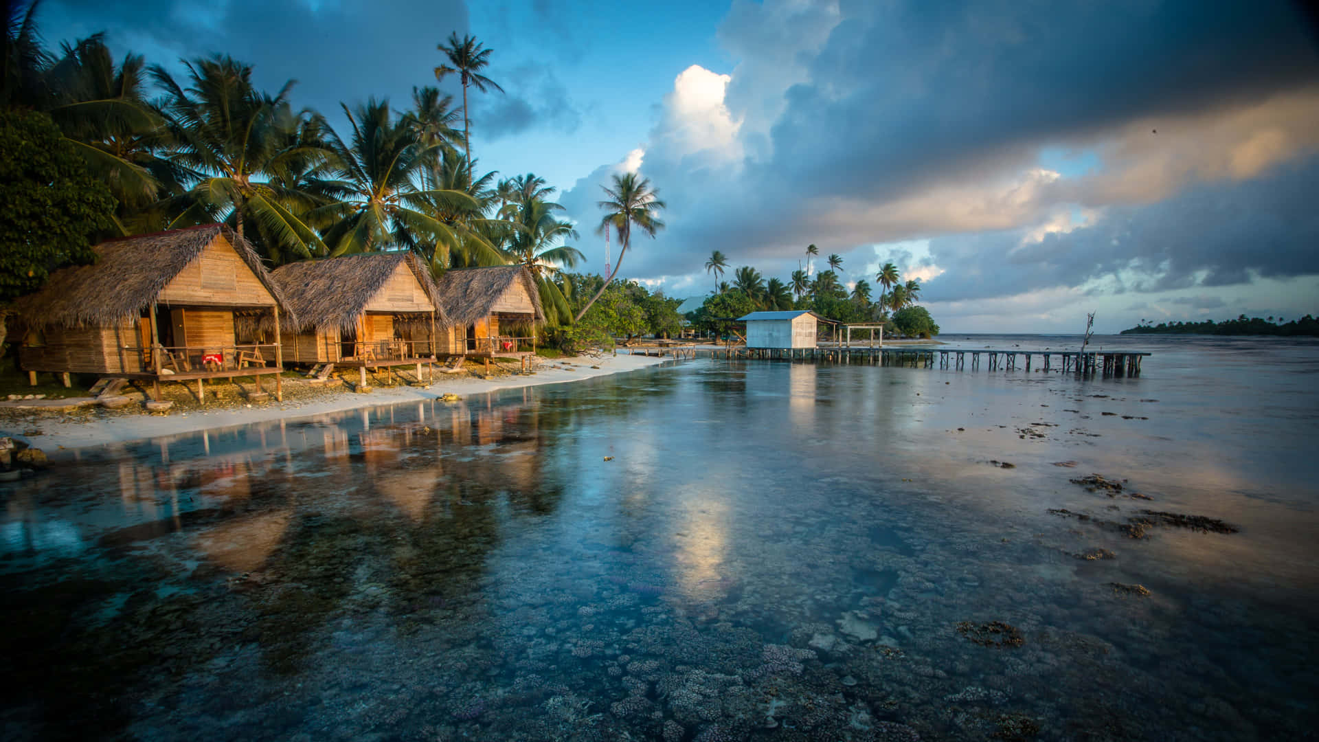 A Mesmerizing Sunset Over A Serene Lake With A Wooden Pier And Lush Vegetation Background