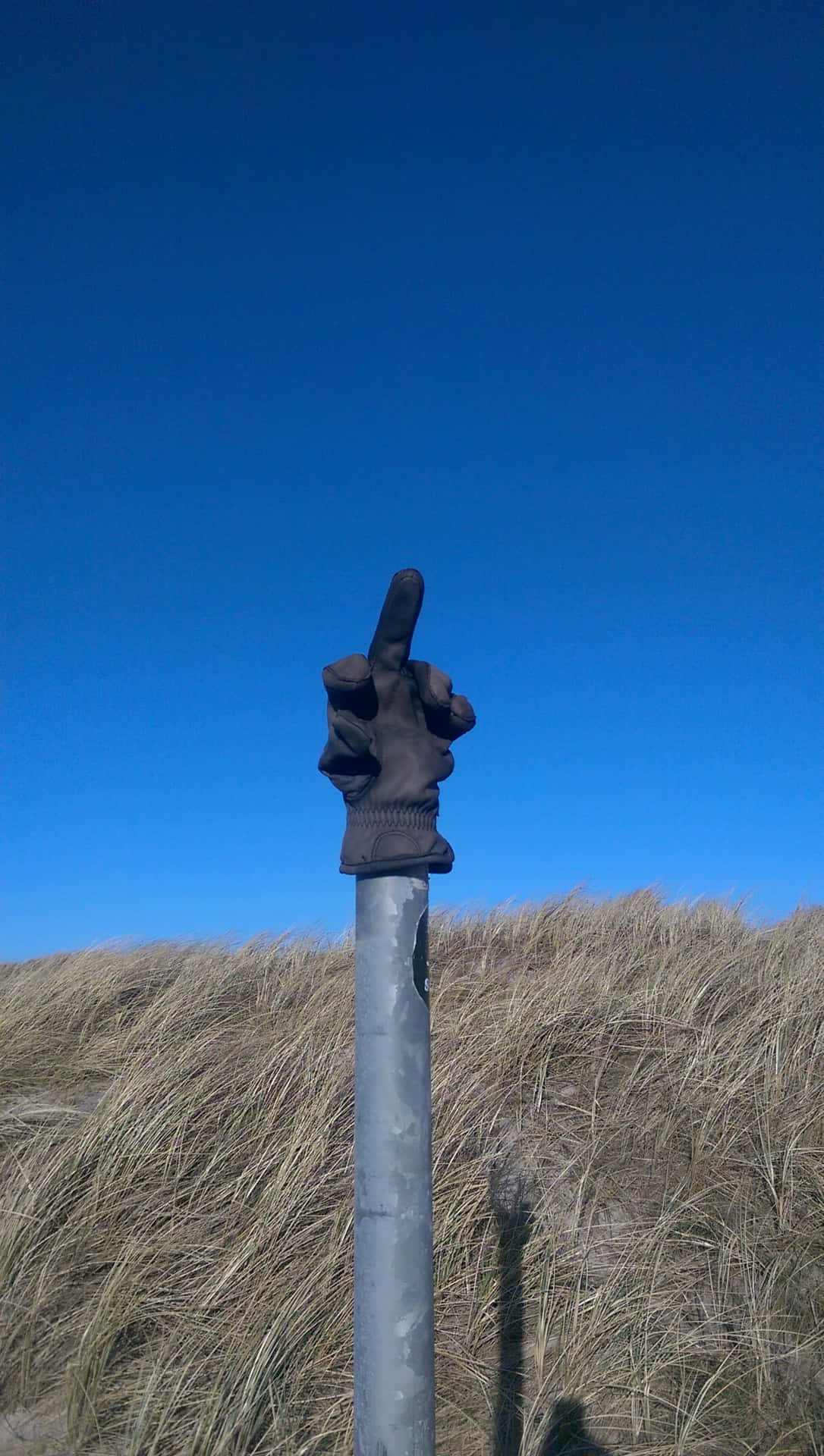 A Metal Pole With A Hand On It