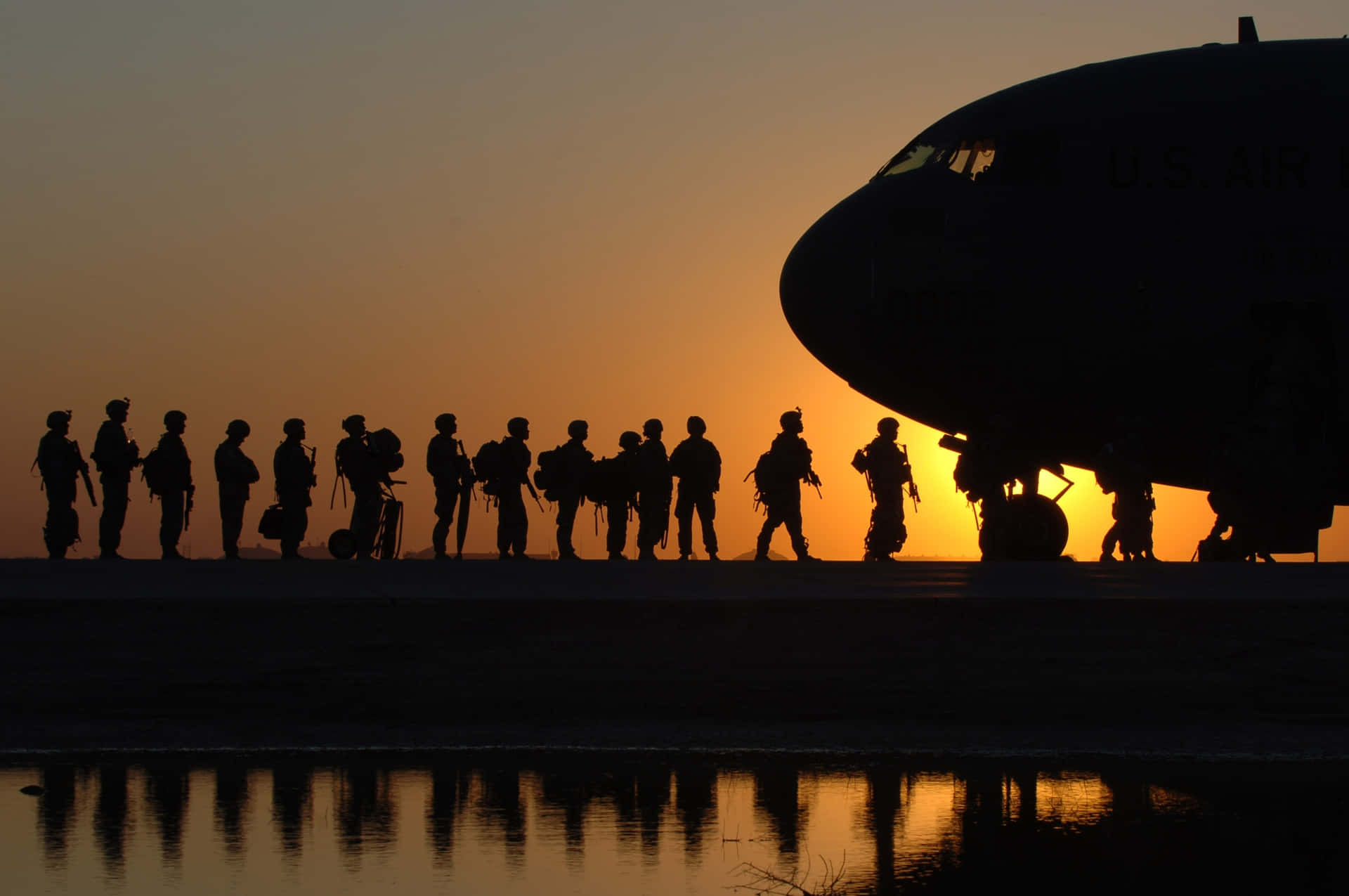 A Military Plane Soars Across The Sky Background