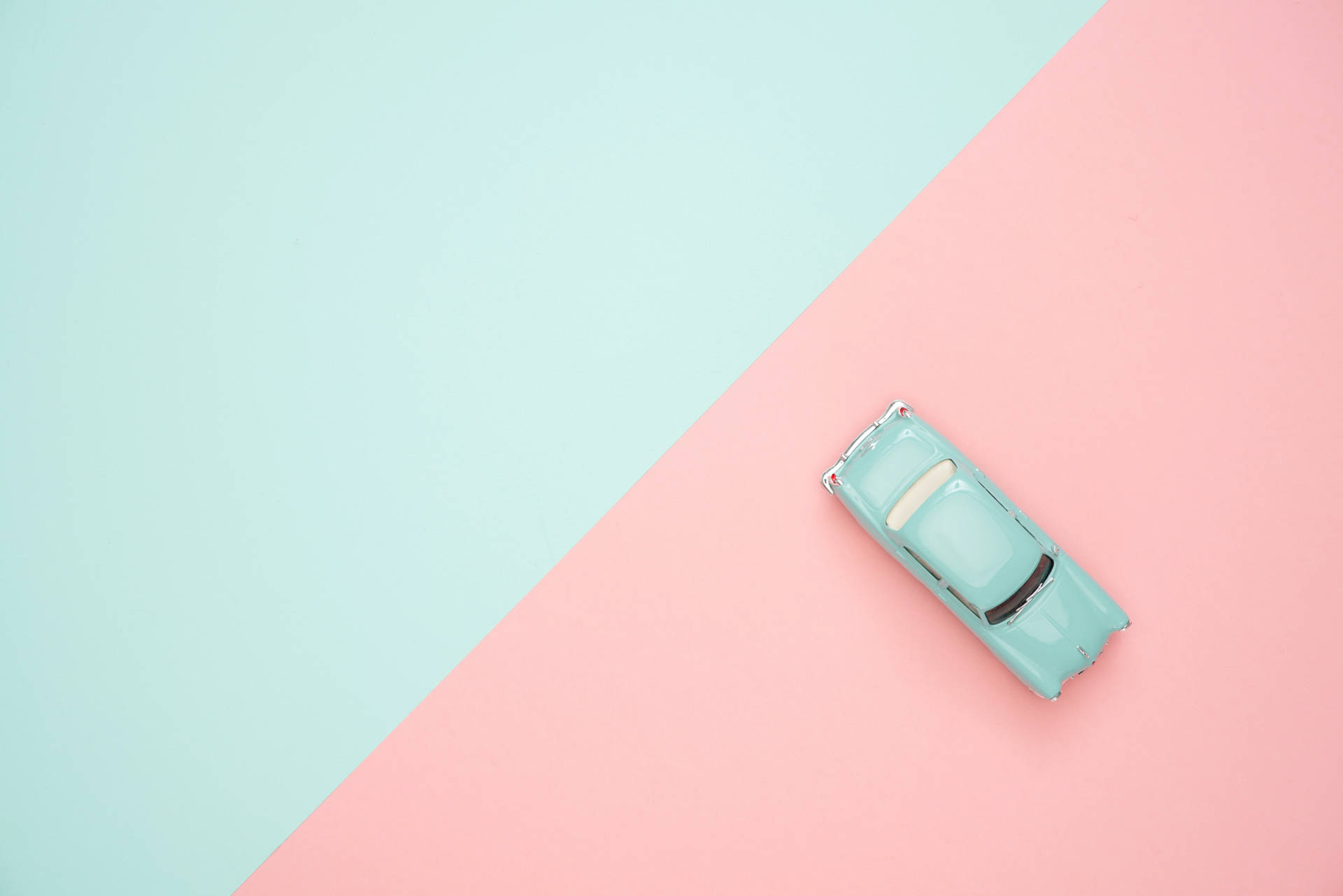 A Mini Toy Car In Pastel Green Background