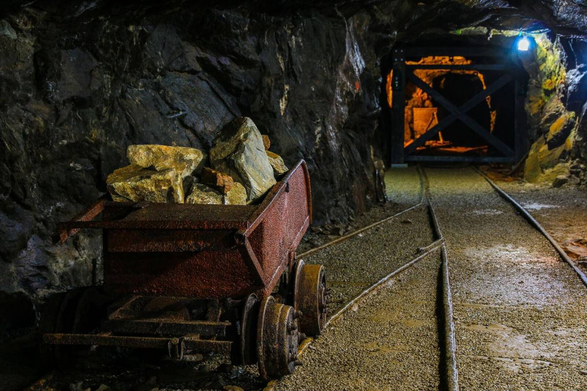 A Mining Cart Full Of Lodes Inside The Goldmines Background