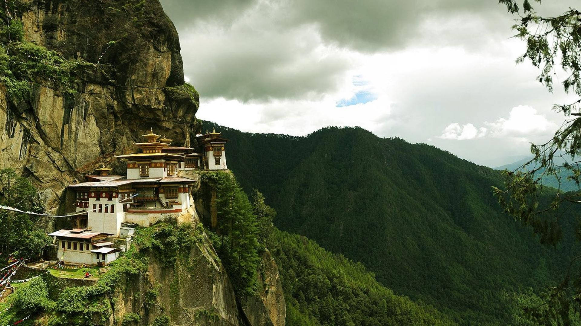 A Monastery Is Perched On A Cliff Background