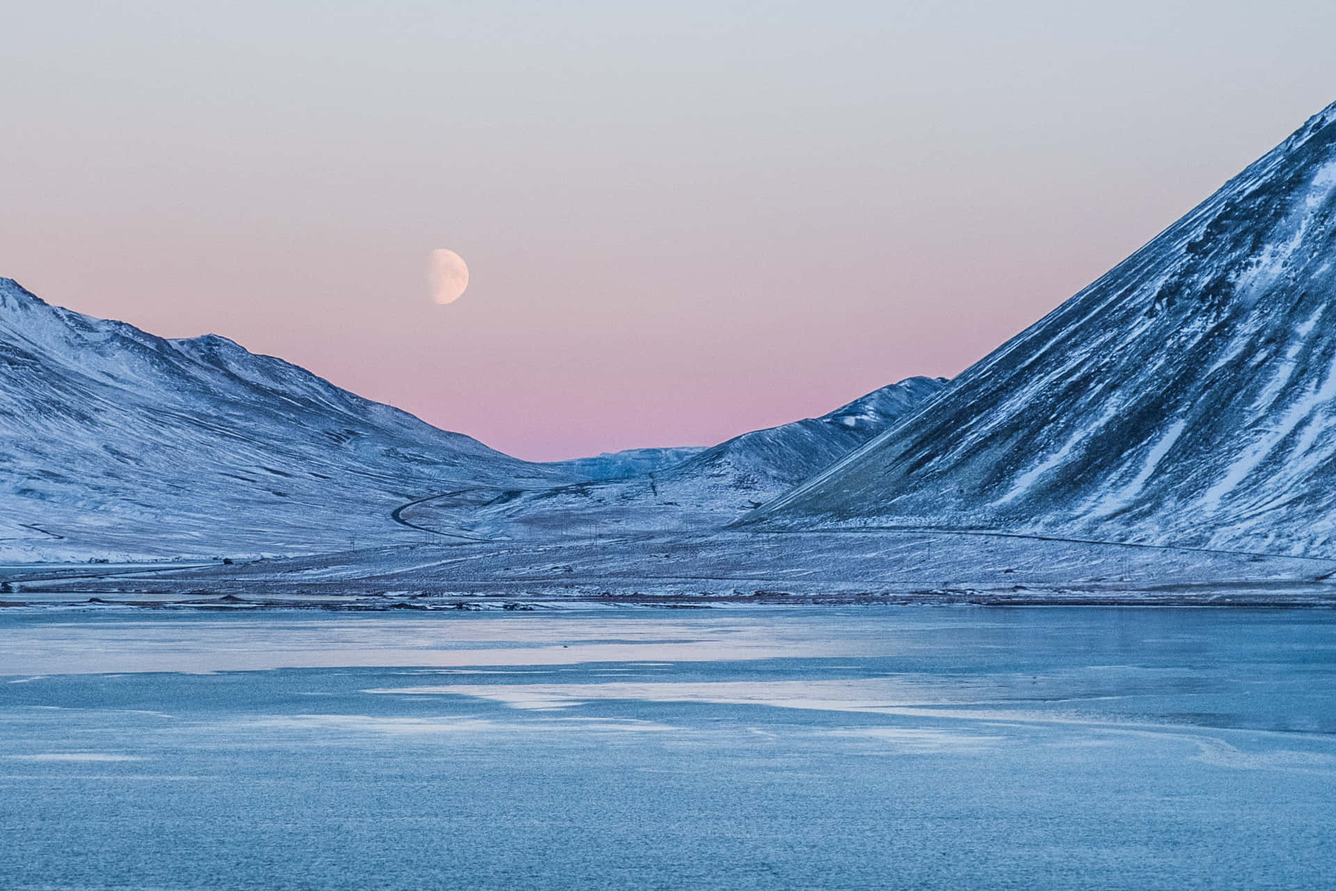 A Moon Rises Over A Mountain And Water Background