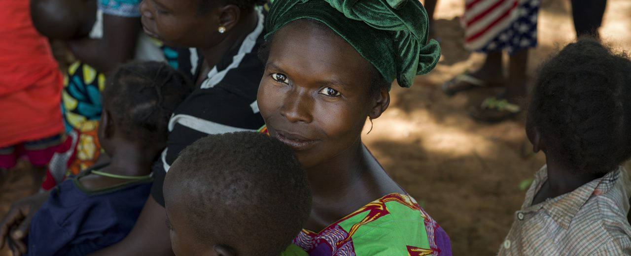 A Mother's Journey - Woman Carrying Her Child In Central African Republic Background