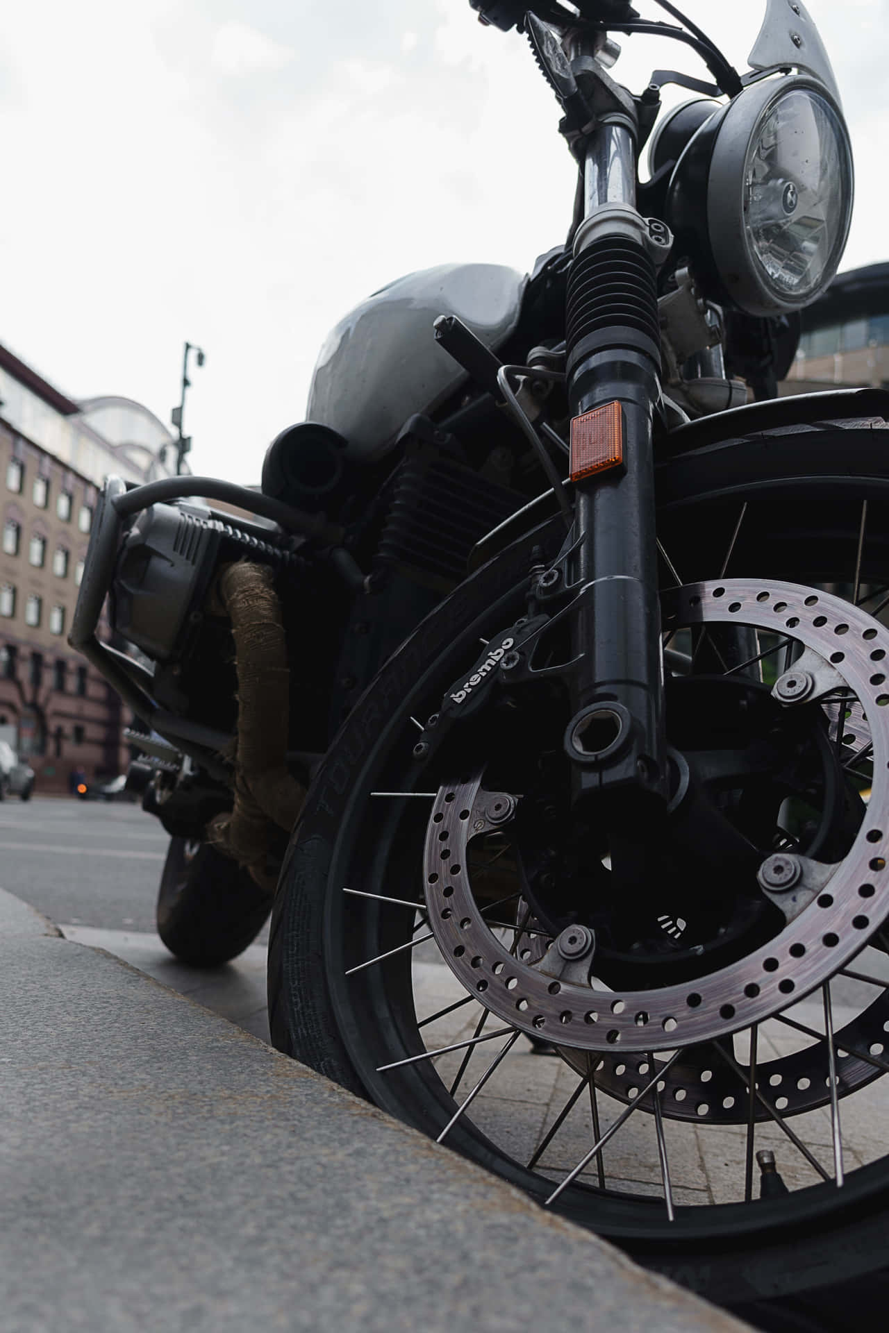 A Motorcycle Parked On The Side Of The Road Background