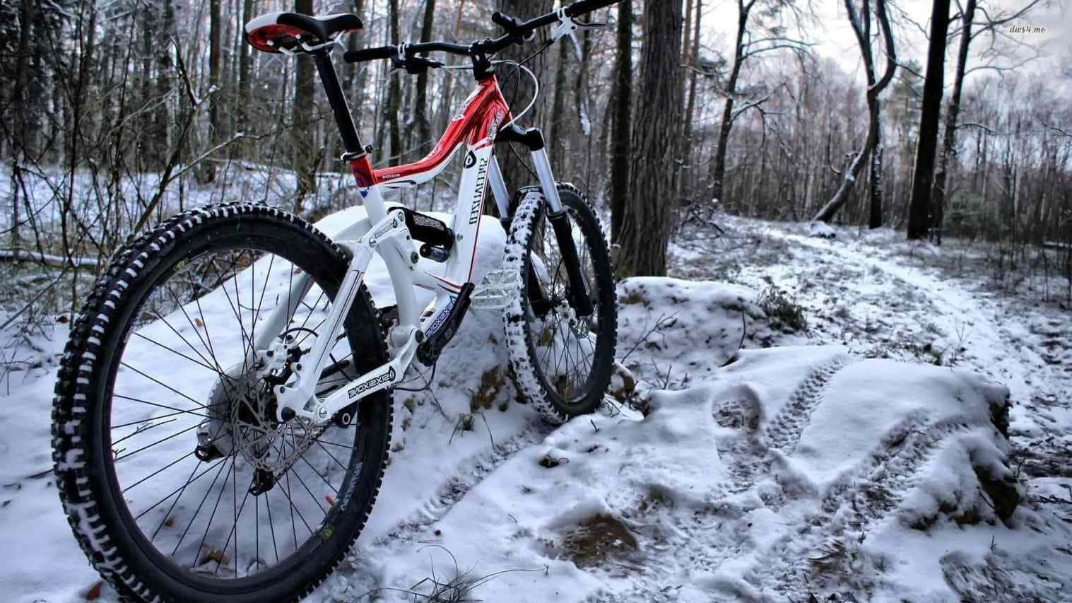A Mountain Bike Is Parked In The Snow Background