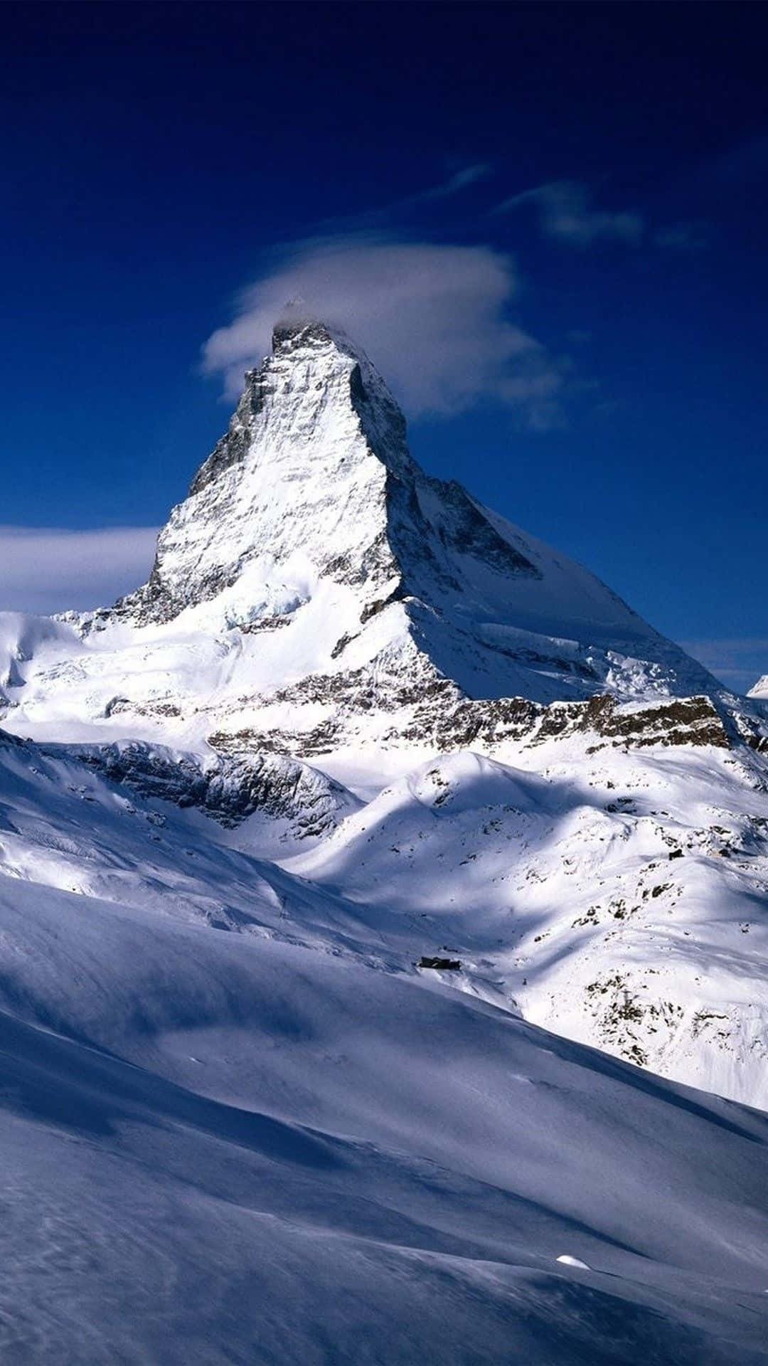 A Mountain Covered In Snow With A Cloud In The Sky Background