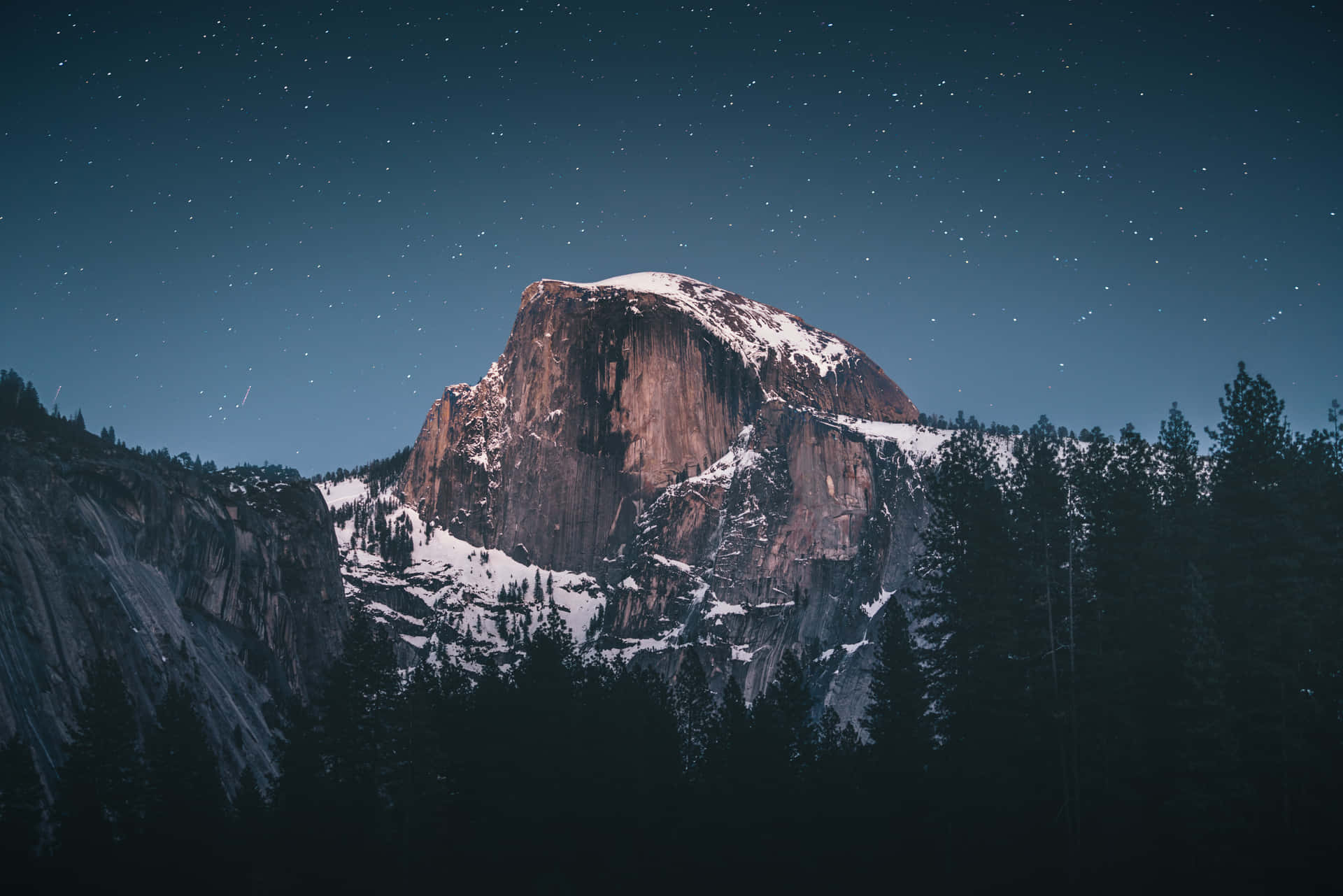 A Mountain Is Seen At Night With Stars Above It Background