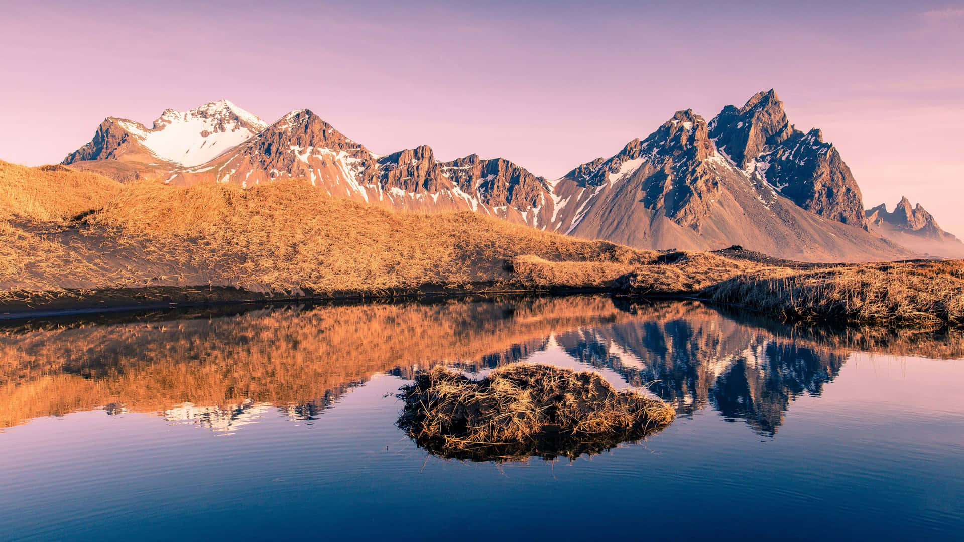 A Mountain Range Is Reflected In A Lake Background
