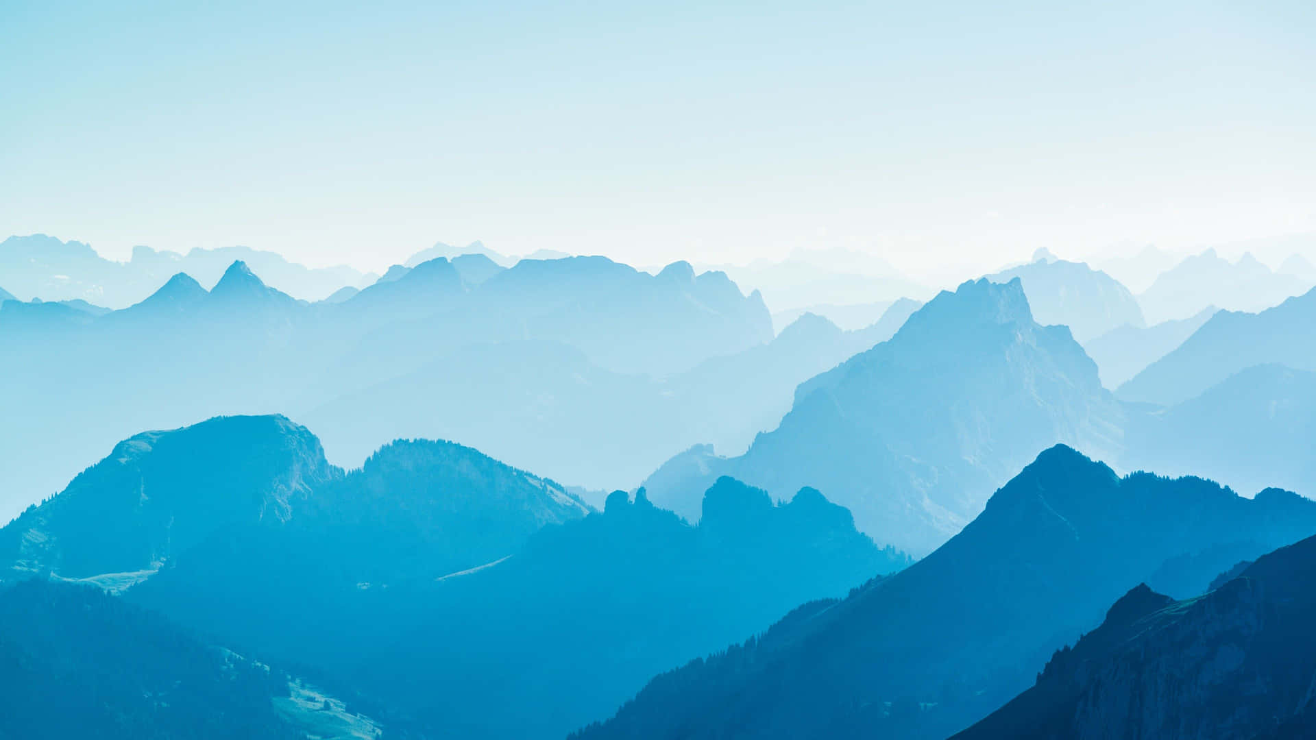 A Mountain Range With A Blue Sky Background