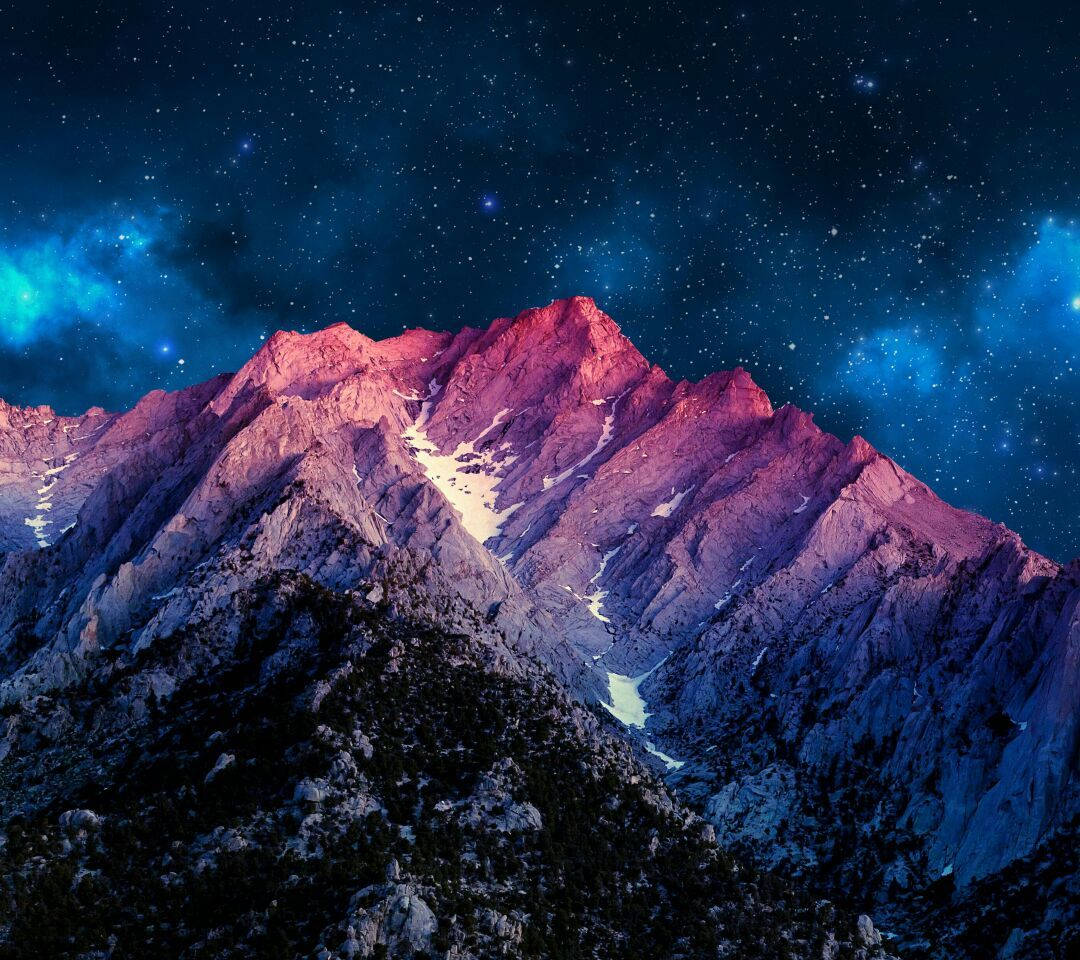 A Mountain Range With Stars And A Galaxy In The Background Background